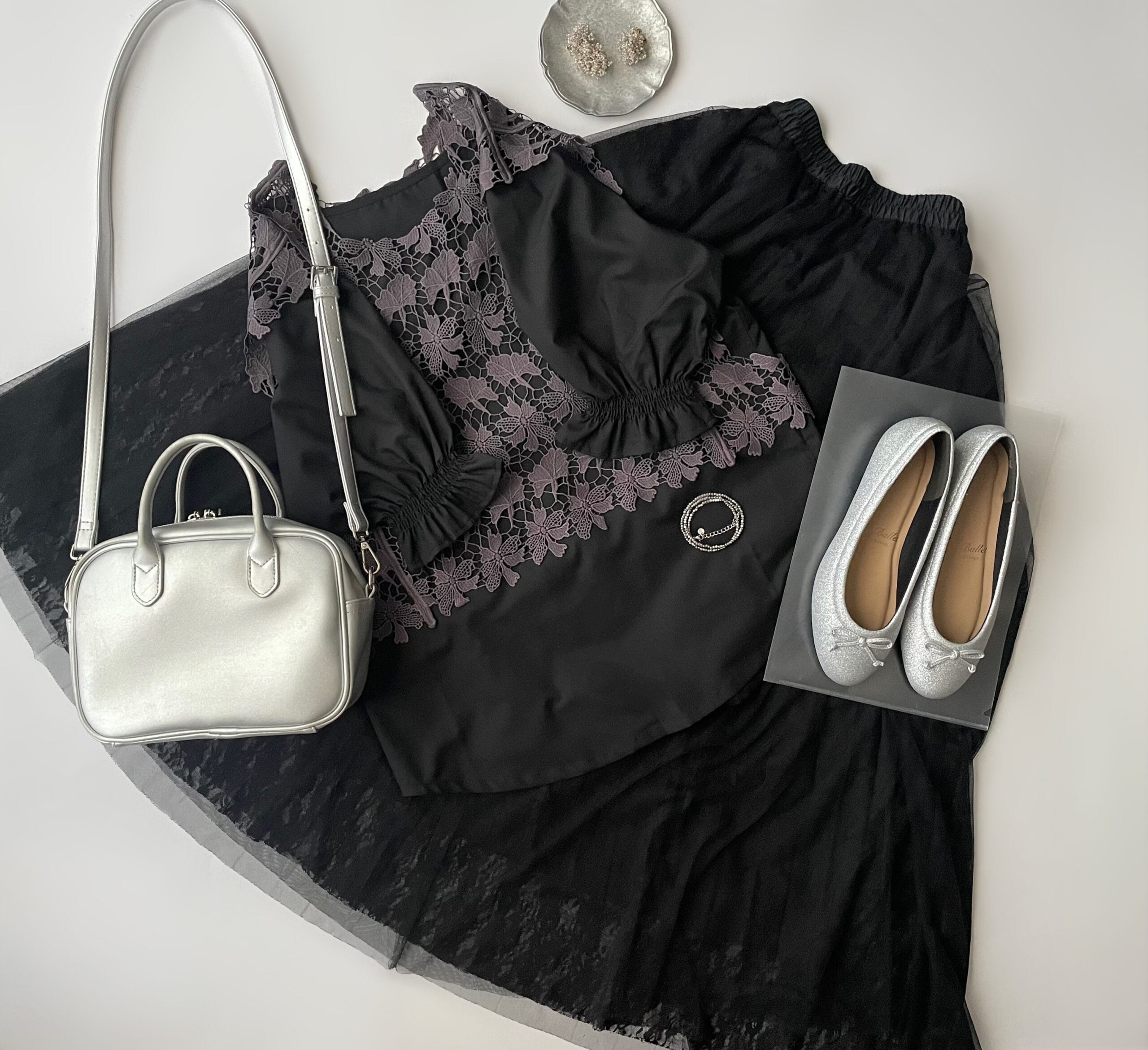 “COCOCee（ここちぃ）”シリーズのバレエパンプス（シルバーグリッター）に黒のブラウス・黒のチュールレースプリーツスカート・グレーのレースベストを合わせたフラットレイ画像。