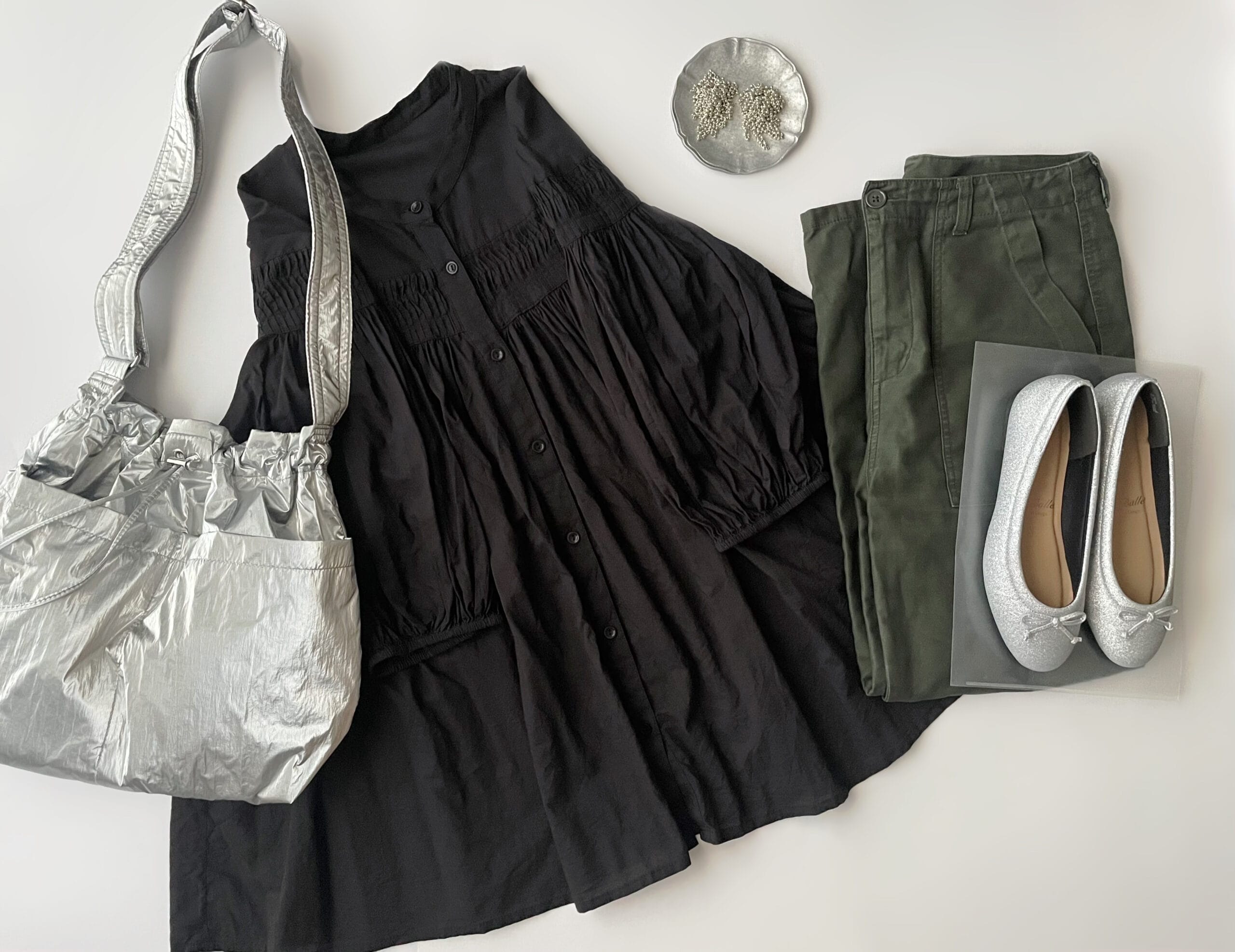 “COCOCee（ここちぃ）”シリーズのバレエパンプス（シルバーグリッター）に黒のタックブラウスとカーキのベイカーパンツを合わせたフラットレイ画像。