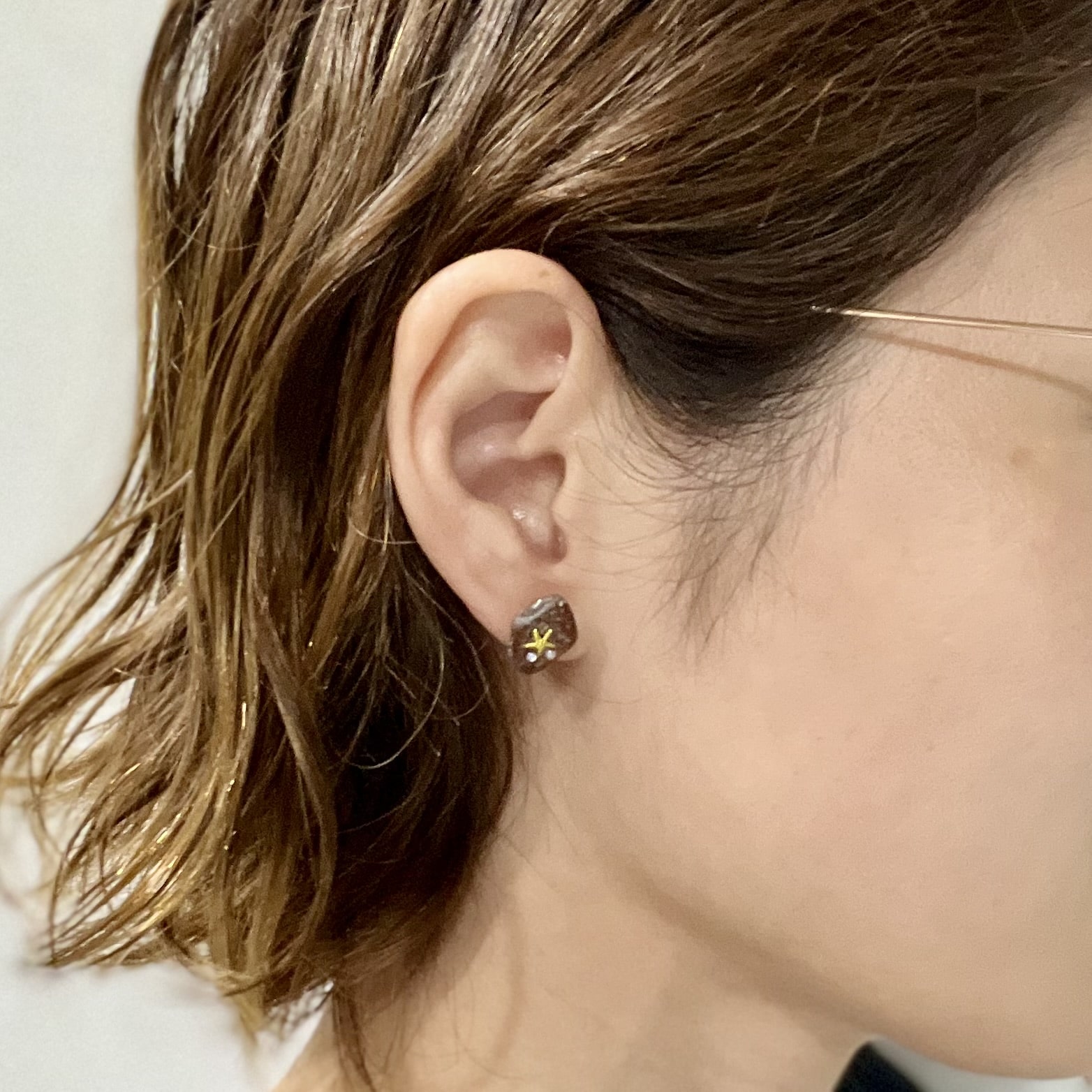 シーグラスとネイルシールで華やかピアスを耳につけた様子