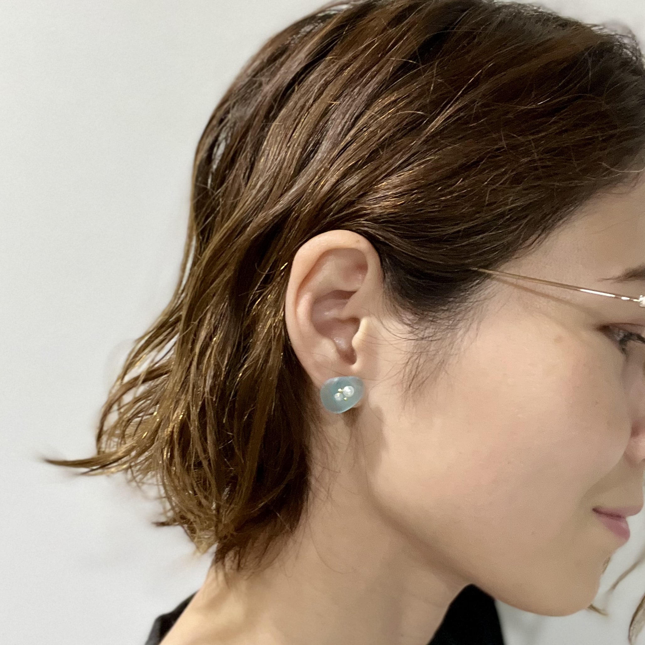 大きめシーグラスピアスを耳につけた様子