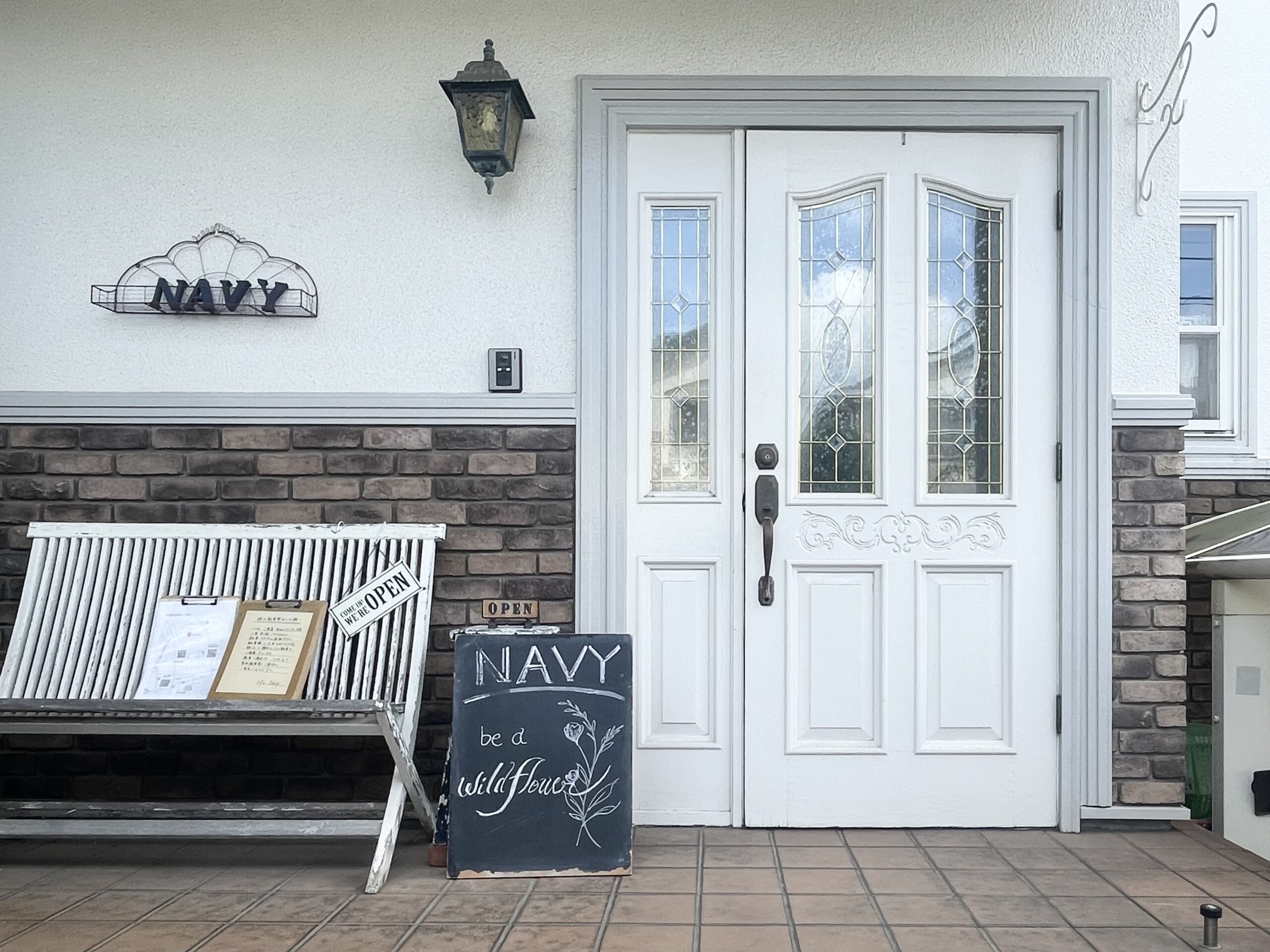 カフェネイビーの外観。ウェルカムボードには“NAVY be a wildflower”と書かれている。
