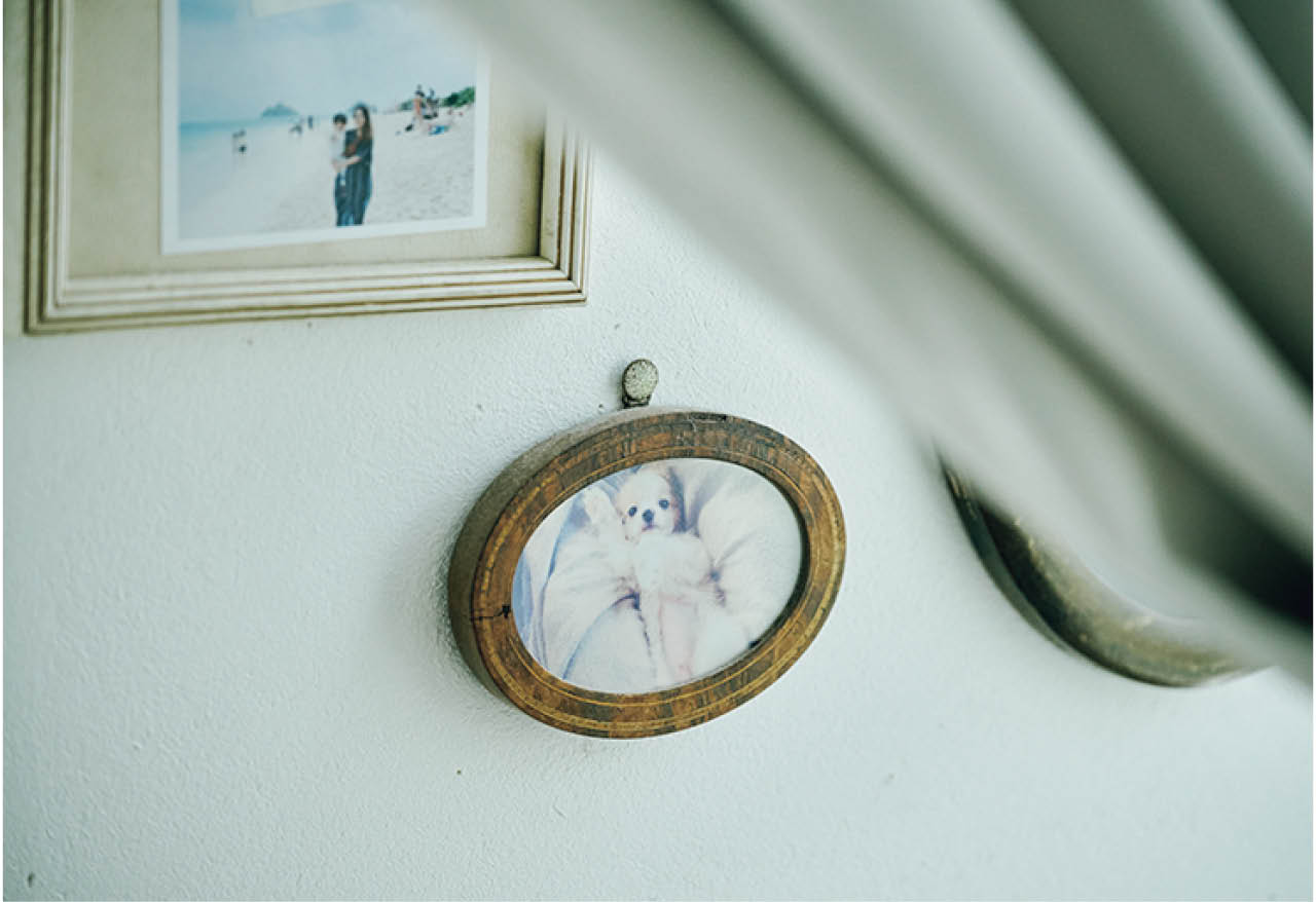 アンティークのフレームに額装し、家族写真とともに壁にディスプレイ。