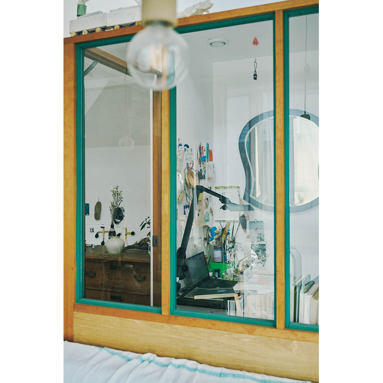 ソファの背面部分にガラス張りで囲った約2畳の空間が。ここがよしいさんの仕事場。