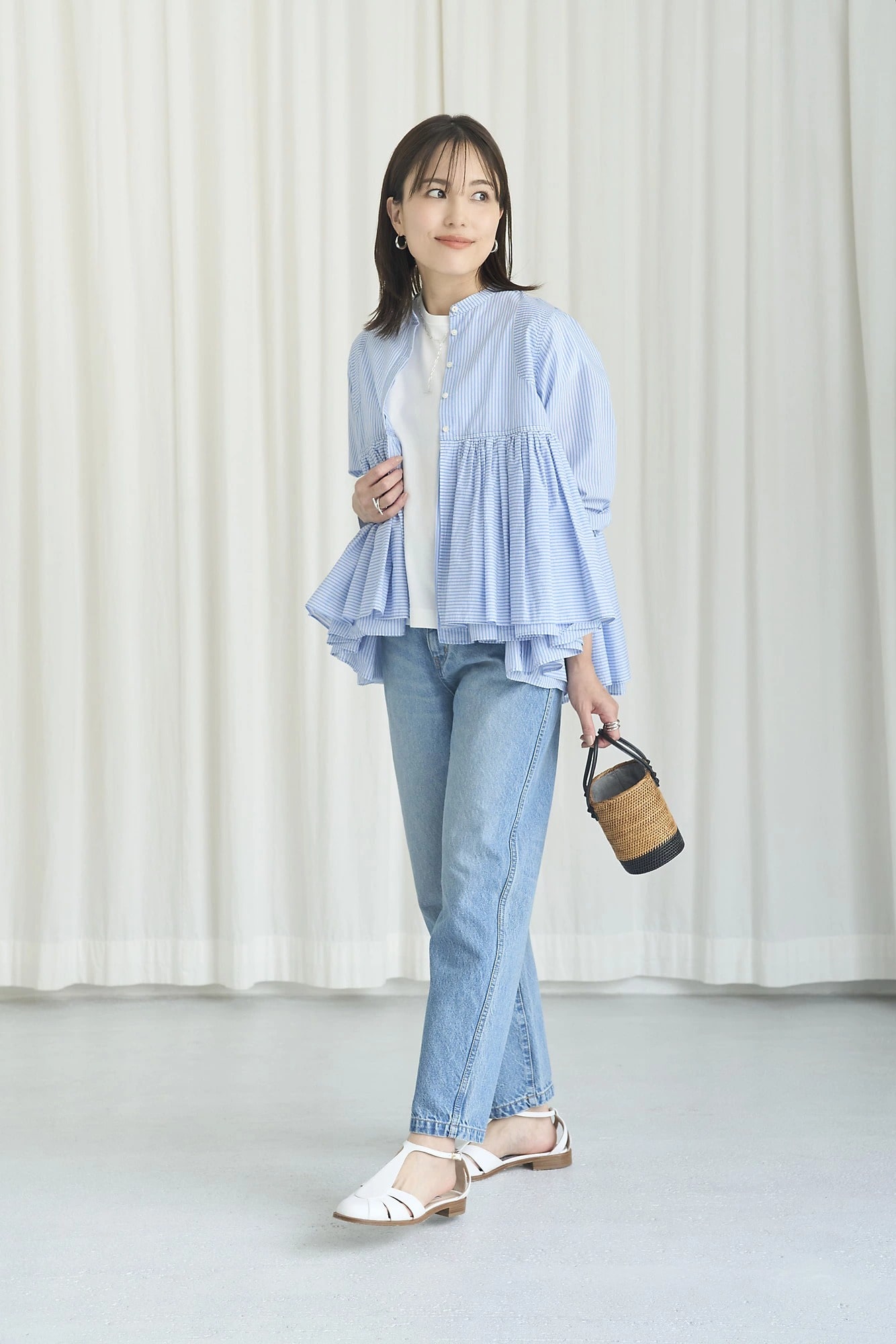 細かなブルー×ホワイトのストライプ生地のフレアギャザーブラウスにウォッシュ加工のデニムを合わせたコーディネート