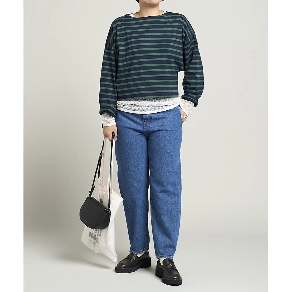 グリーン×ネイビーのボーダーカットソーに白のレーストップスをレイヤード、ストレートデニムを合わせたコーディネート