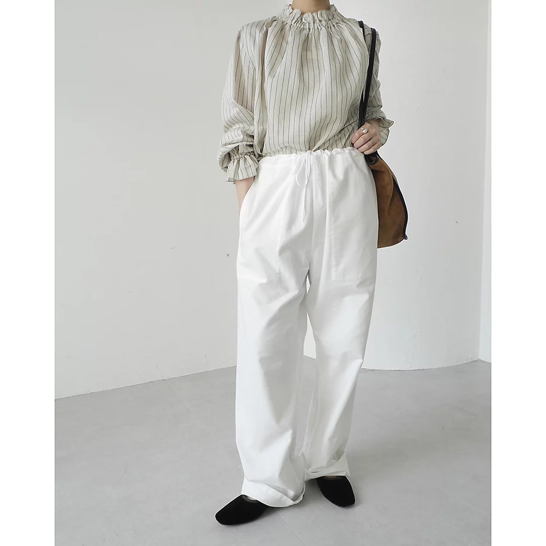 ストライプのシアーブラウスとホワイトパンツのコーディネート