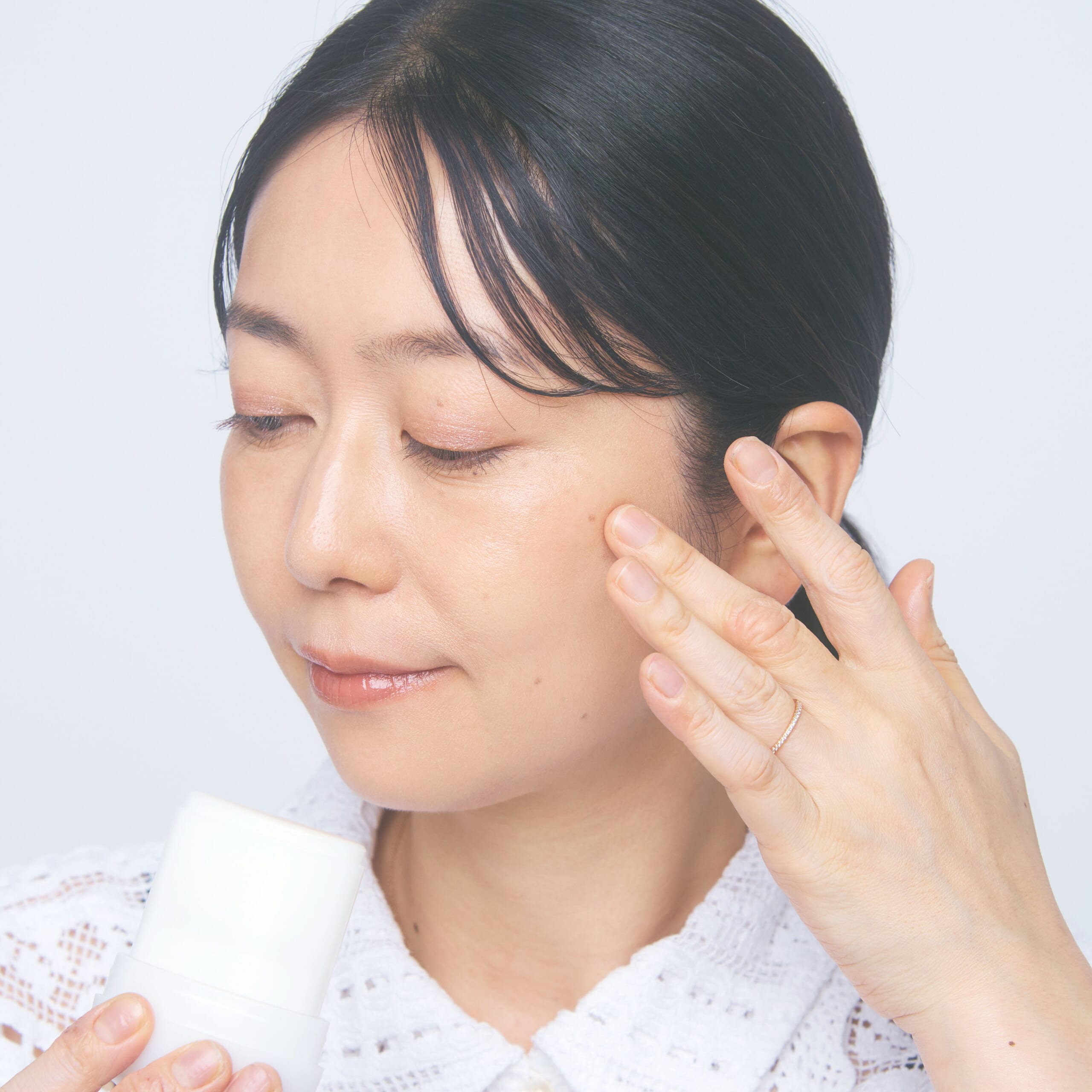 グロウイング バームを頬に塗っているところ。