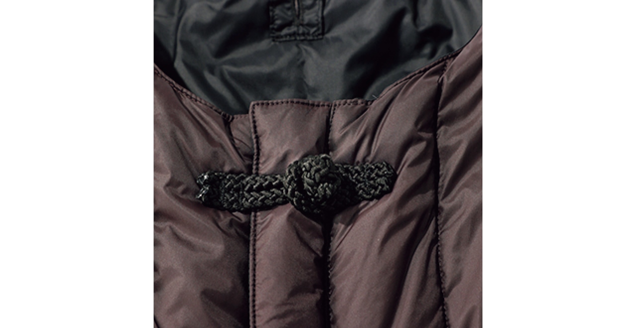 高密度ナイロン生地×上質なダウンで、薄くても保温性は抜群。ダークブラウン地の縦キルトには、すっきり見え効果も。