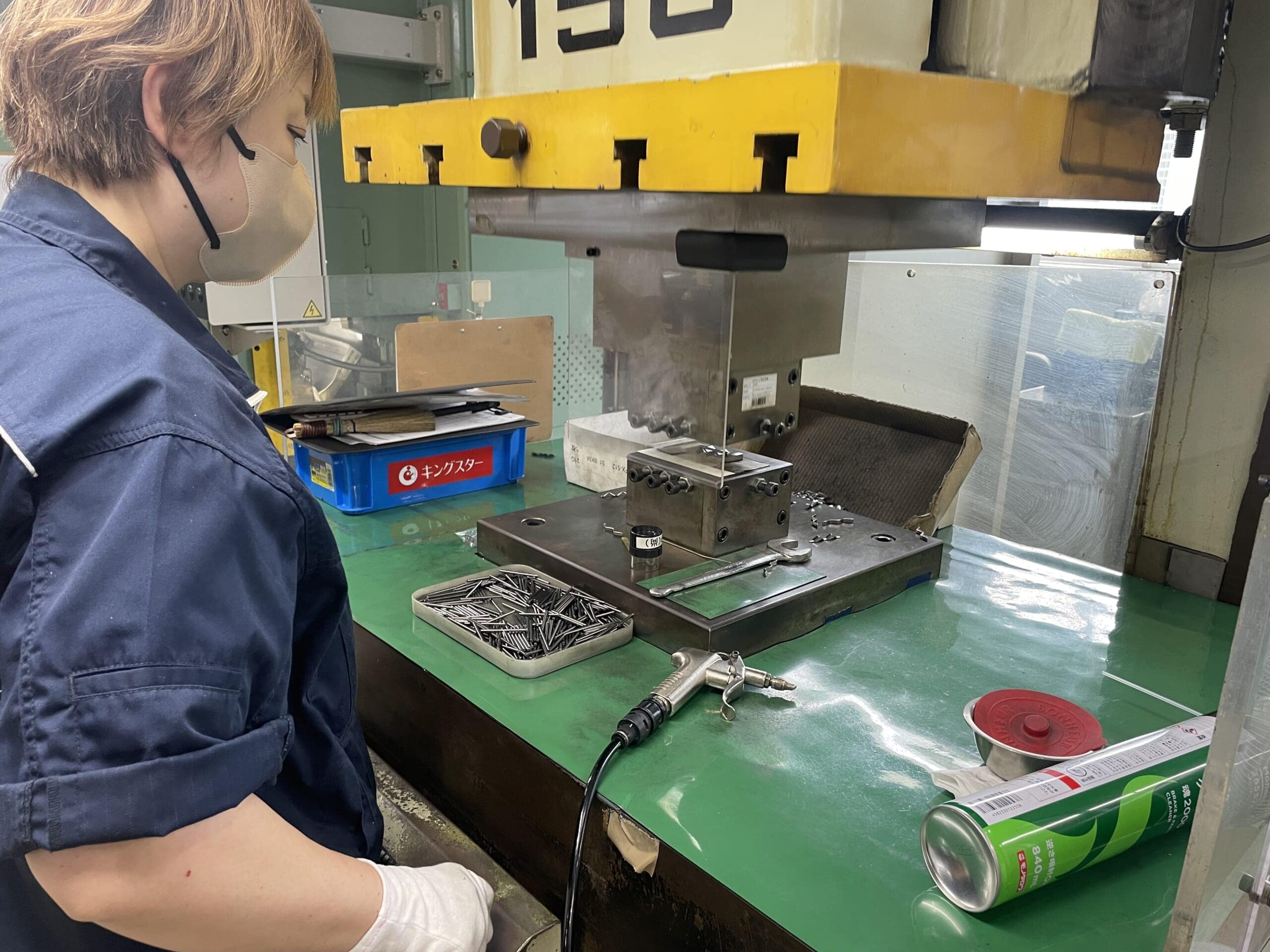 ヨロイをプレスする機械と職人さん