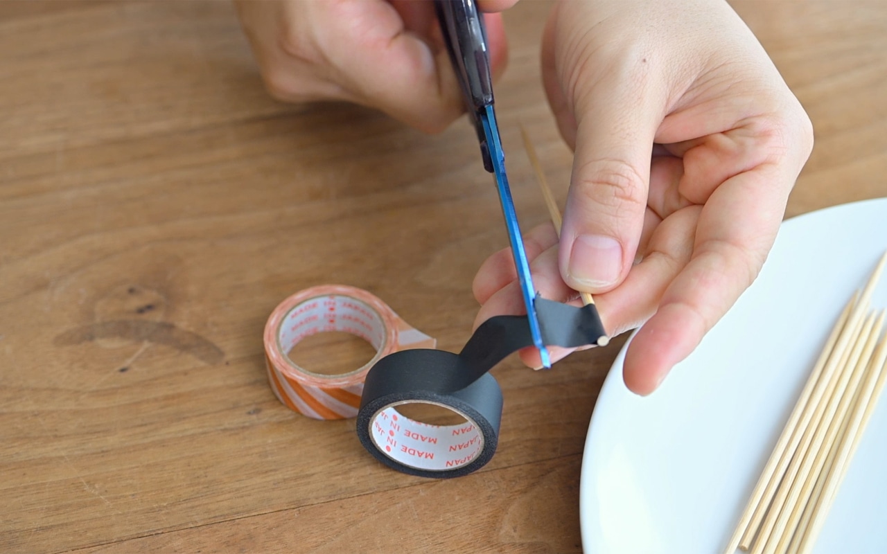 竹串の頭にマスキングテープを巻きつけ半分に折り、好みの長さにハサミで切り旗を作る。