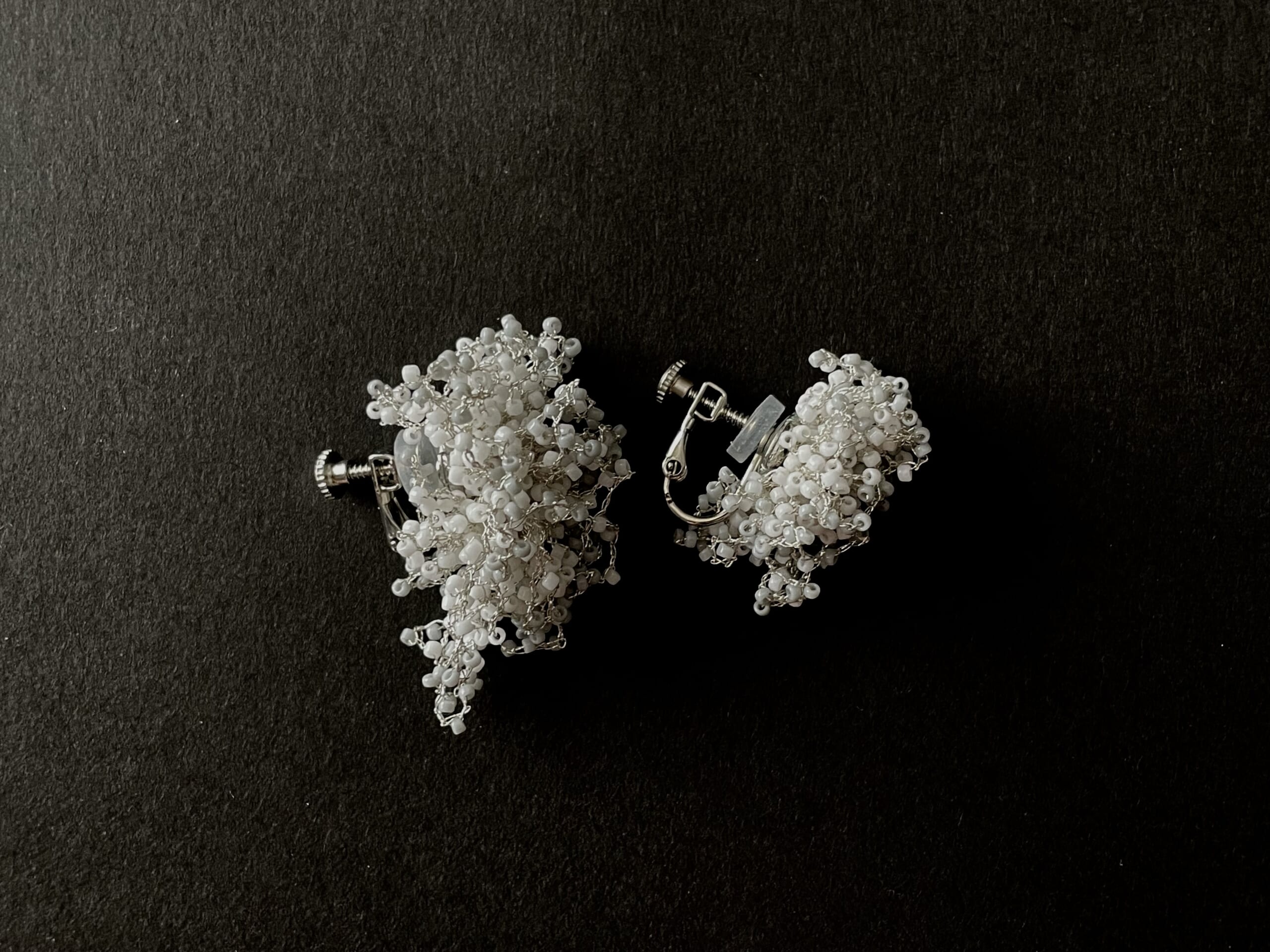 Applepheromone（アップルフェロモン）のガラスビーズと銀糸のイヤリング写真2。背景が黒。