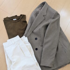 ブラウンのTシャツ、白のワイドパンツ、チェックのダブルジャケット平置きしたコーディネートの写真
