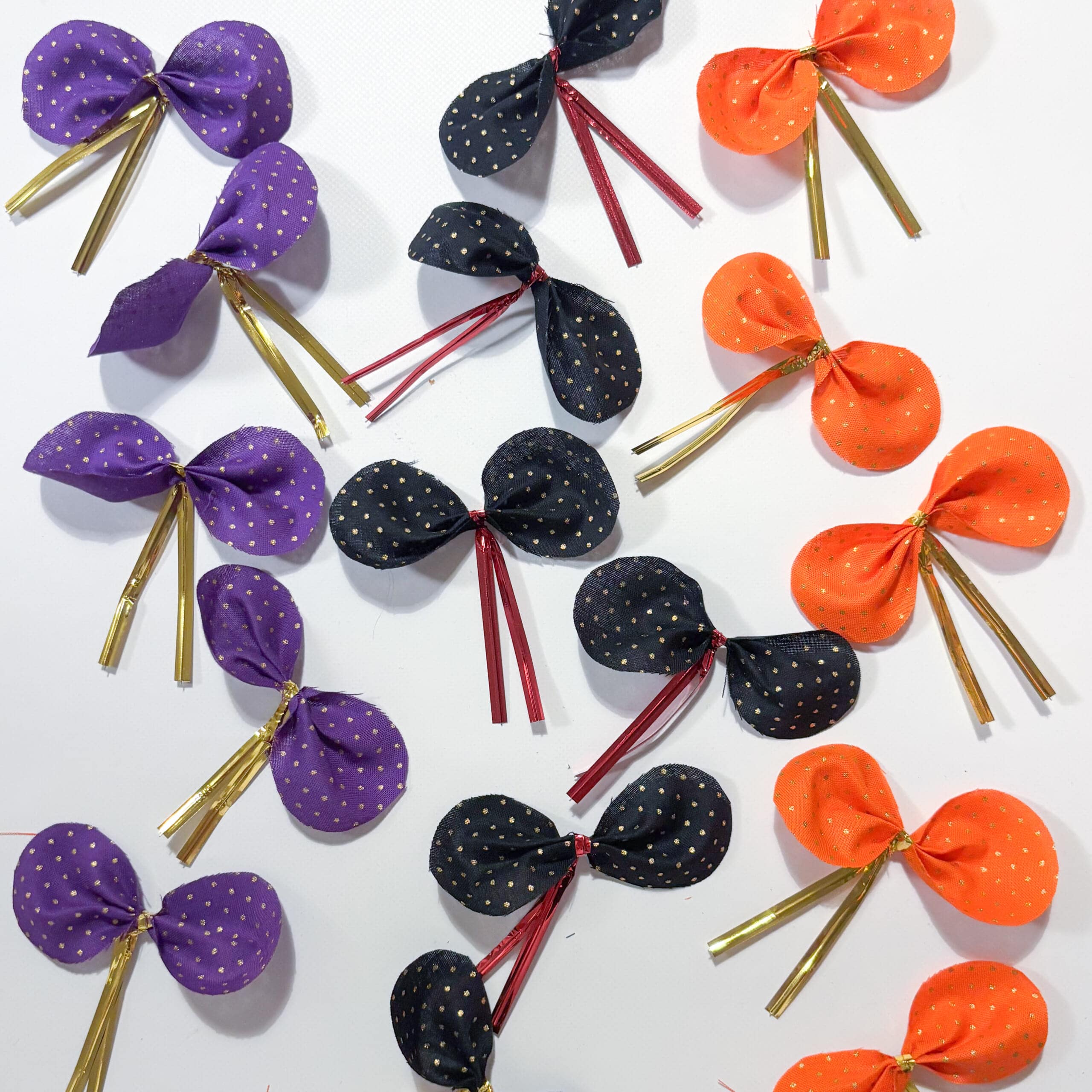 オレンジ、黒、紫の布で作ったリボンがたくさん並ぶ様子