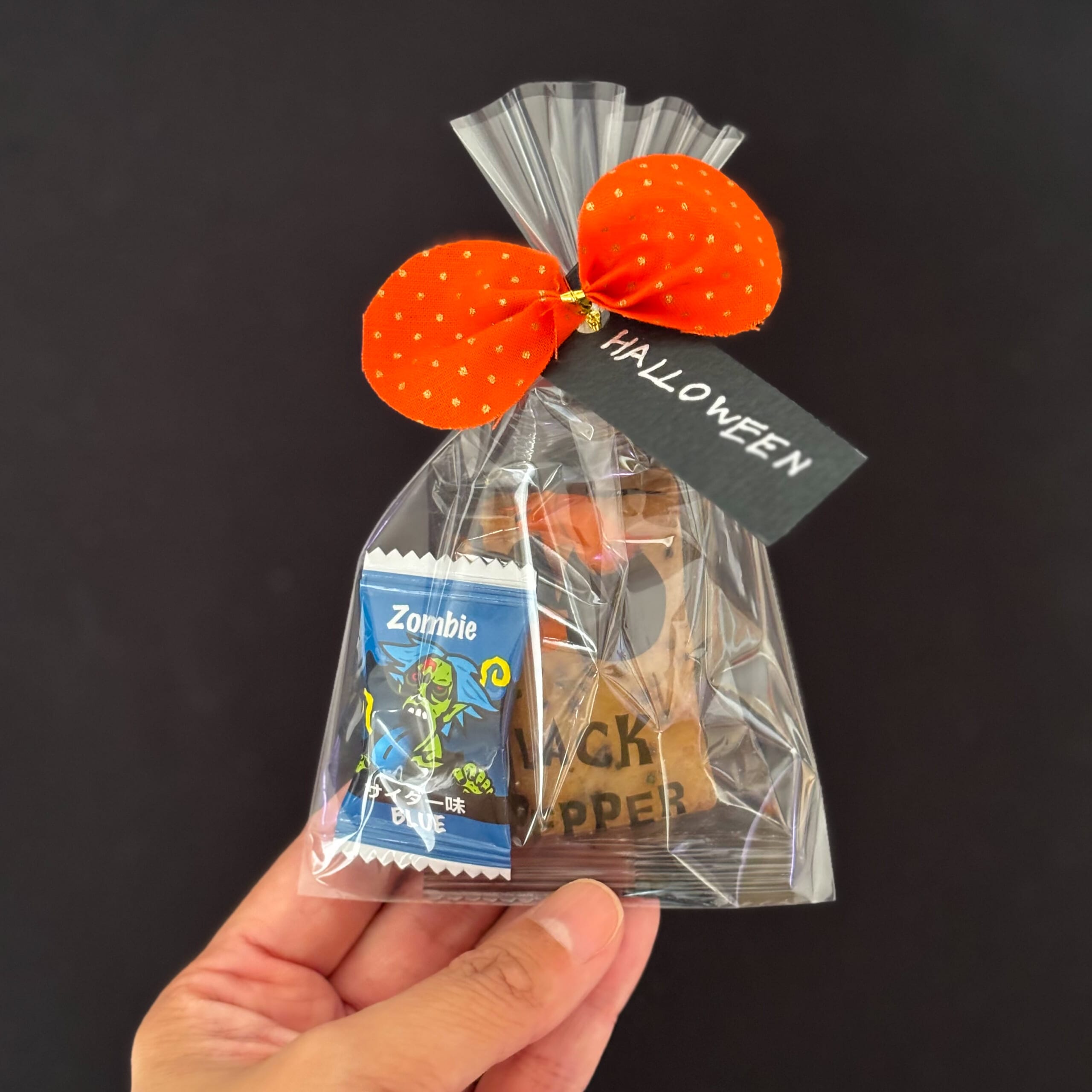 オレンジのリボンとHalloweenと書かれた黒いタグでラッピングした、お菓子のプチギフト