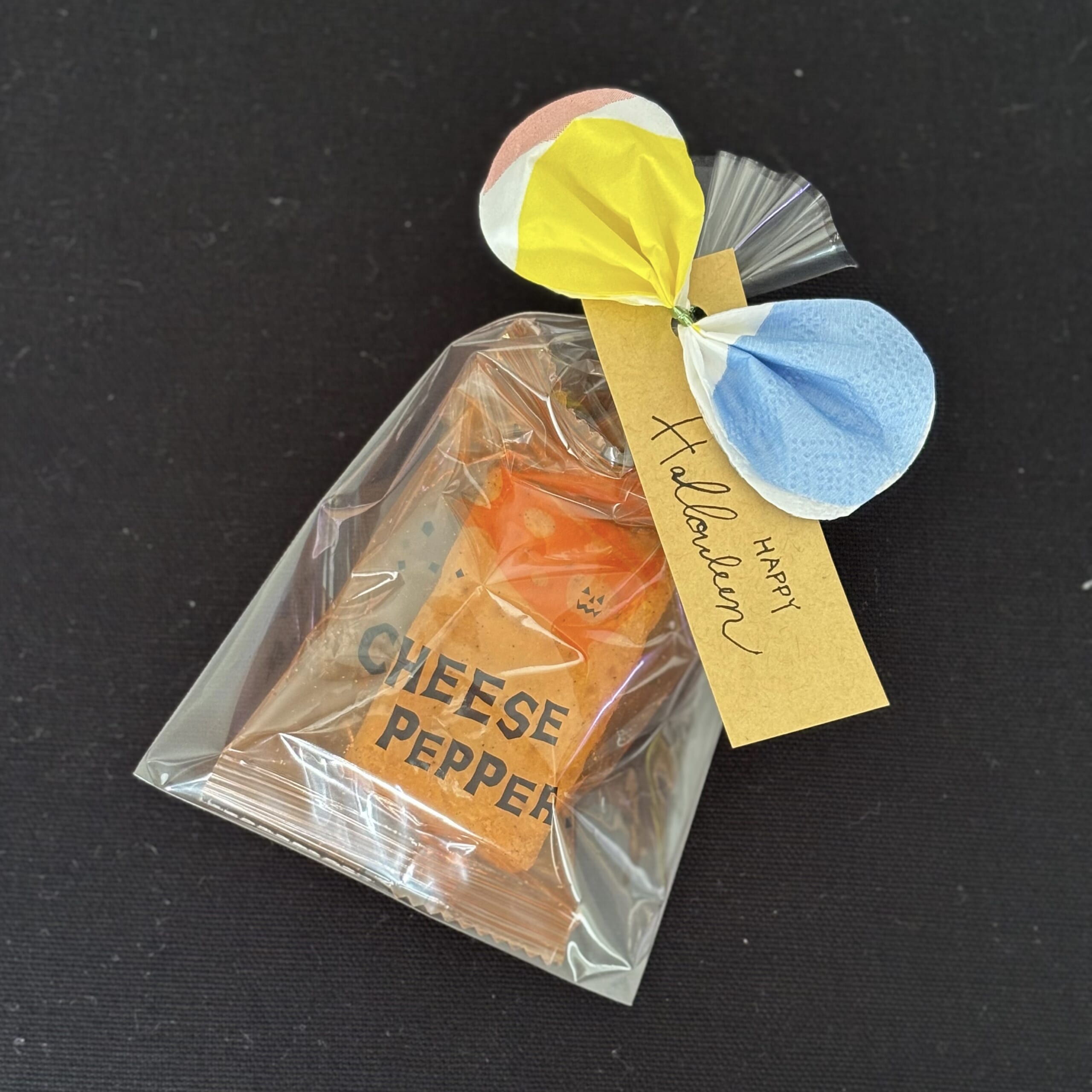 ペーパーナプキンのリボンと茶色のタグでラッピングしたお菓子のプチギフト