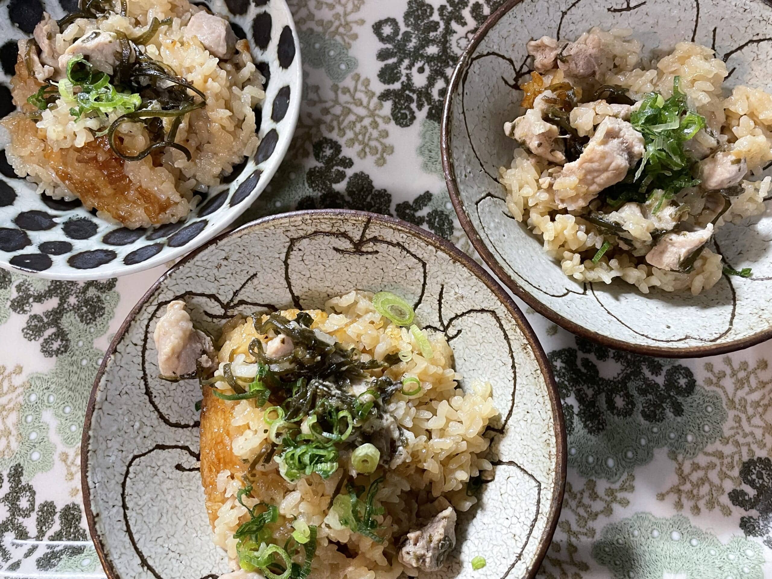 長谷川あかりさんのレシピ「豚肉と塩昆布の炊き込みごはん」を40代主婦が作ってみて、器に盛り付け、ネギをトッピングした写真。