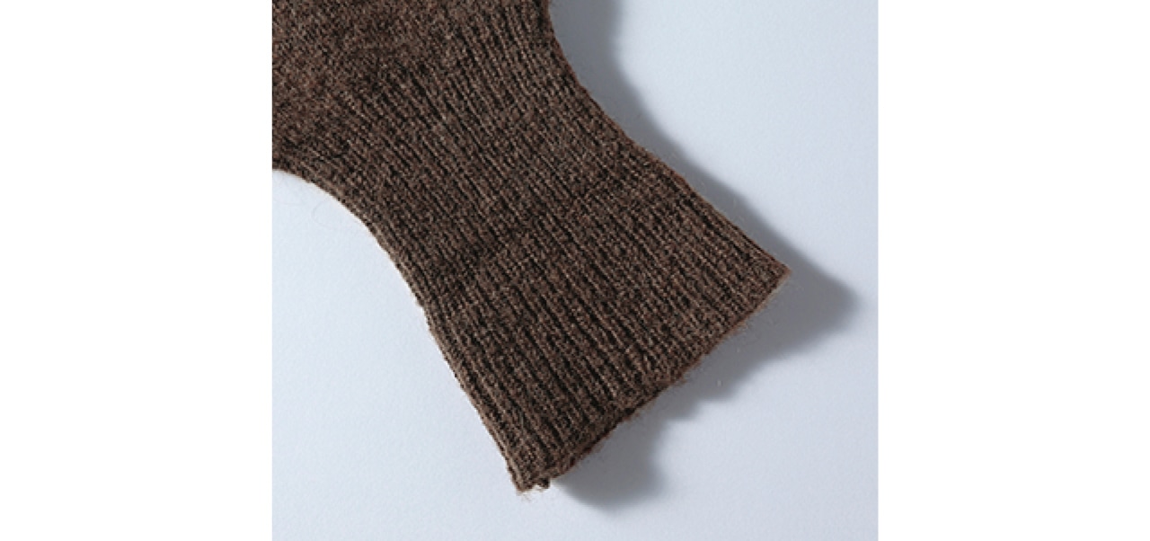 アームウォーマーのように指先までおおう袖口は、たくし上げたときも腕に心地よくフィットするリブ編みに。