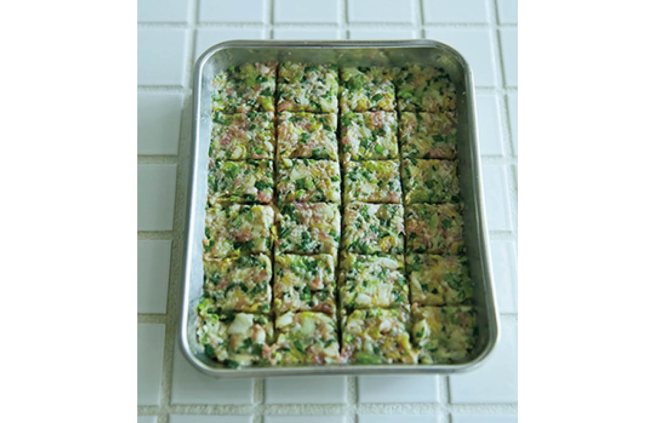 タネをバットに入れて平らにならし、24等分に線を入れておくと余ったり足りなかったりせず、等分に包める。