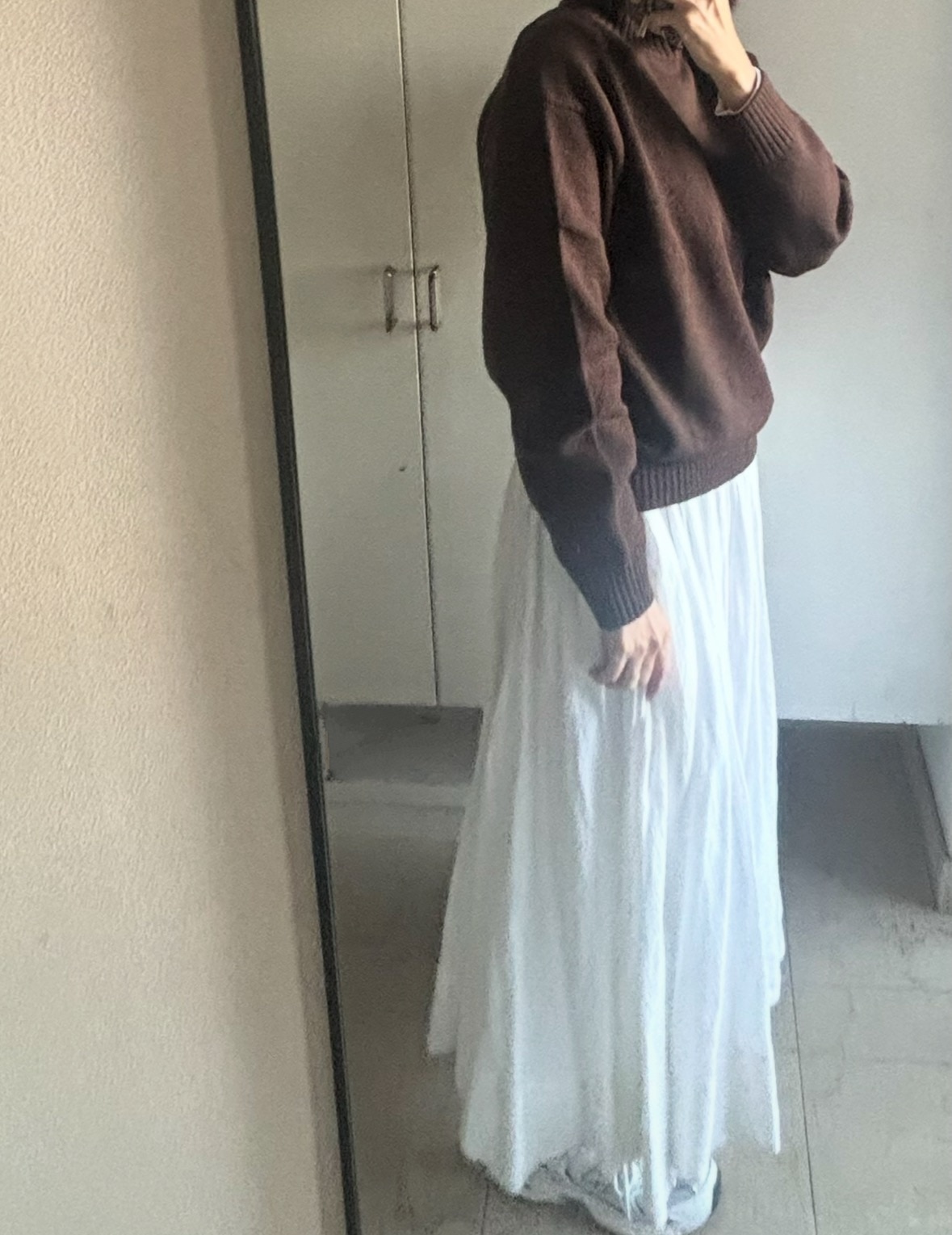 「ユニクロ：シー」のローゲージハイネックセーターと白スカートのコーデ