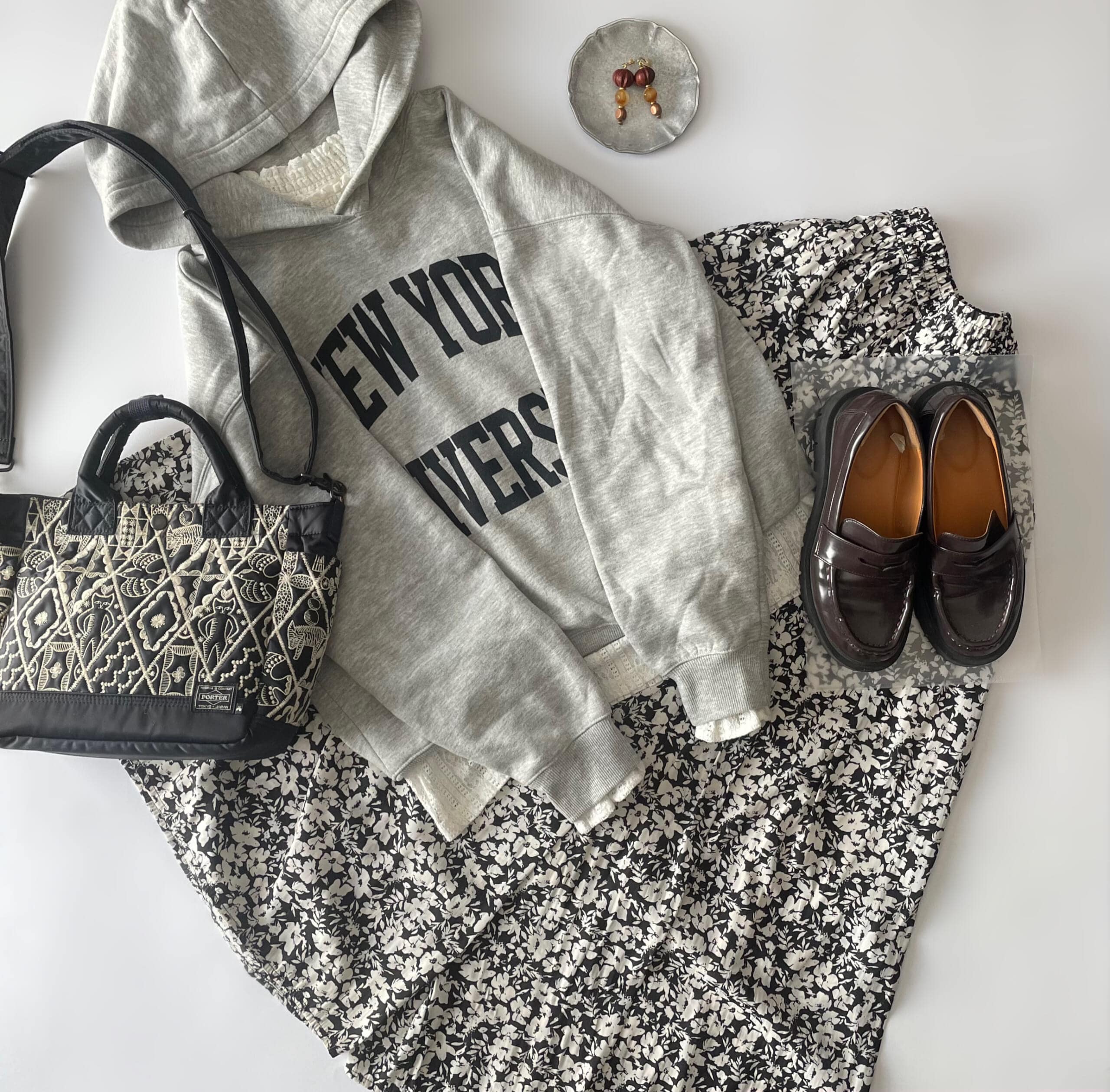 40代主婦の2025年10月下旬コーデ。GUのカレッジロゴフーディパーカにanyFAMの小花柄パンツを合わせたフラットレイ画像