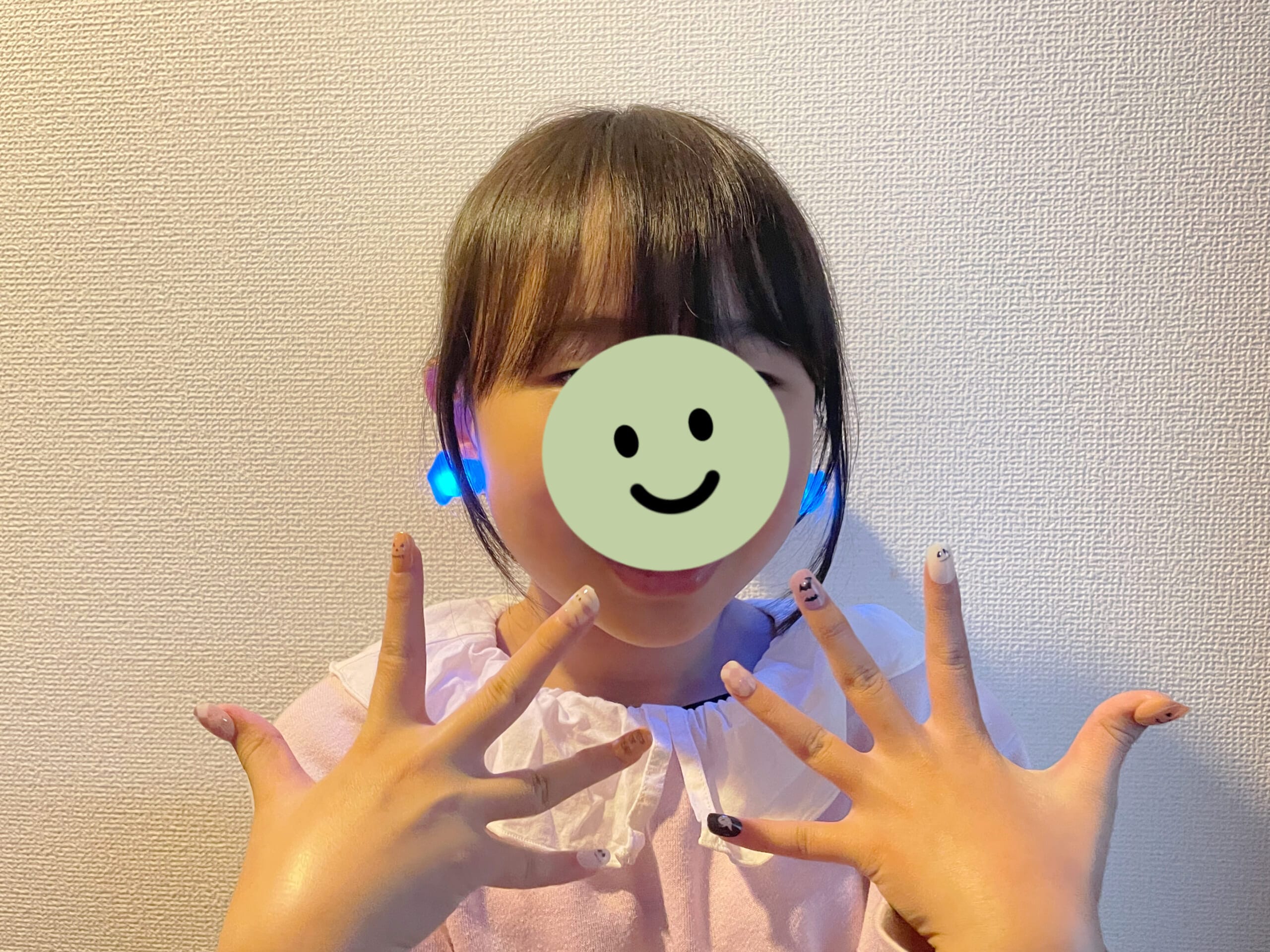 スリーコインズのハロウィンのKIDSネイルチップと光るイヤリングを装着した様子