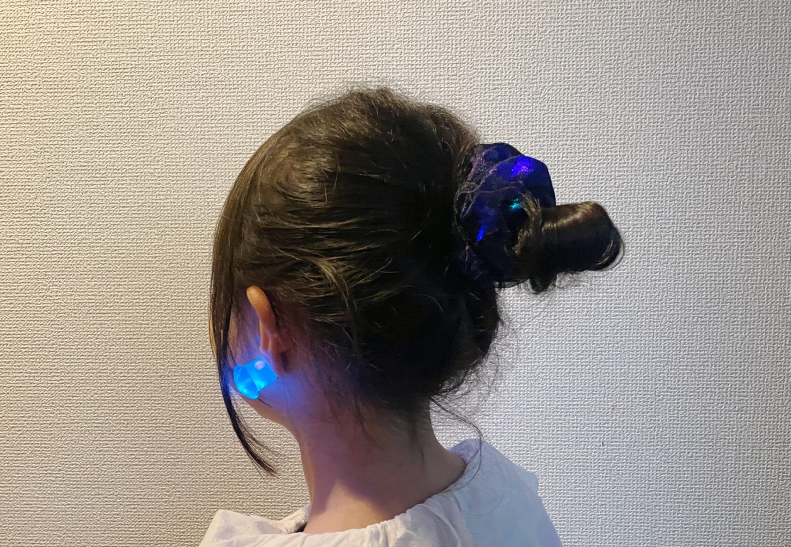 スリーコインズの光るイヤリングと光るシュシュを装着した写真