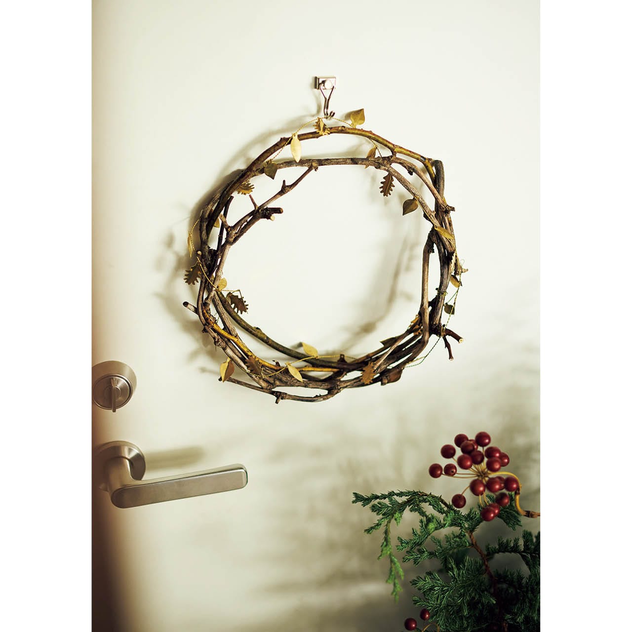 ツタのリースに真鍮の飾りを巻いて