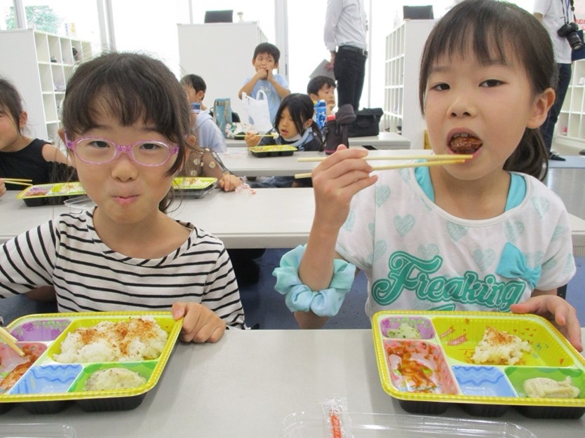 長期休暇中、学童保育でお弁当を食べる児童たち