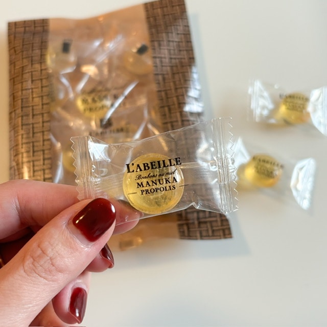 L’ABEILLE/ラベイユ・マヌカキャンディを手に持った写真