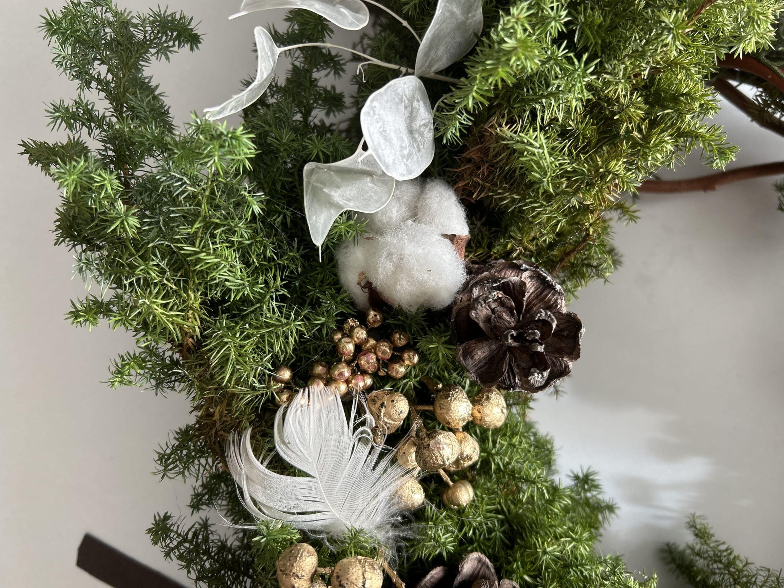 鳥の羽やルナリア、リボンとゴールドのベルをつけて、上品で大人っぽいクリスマスリースの完成。