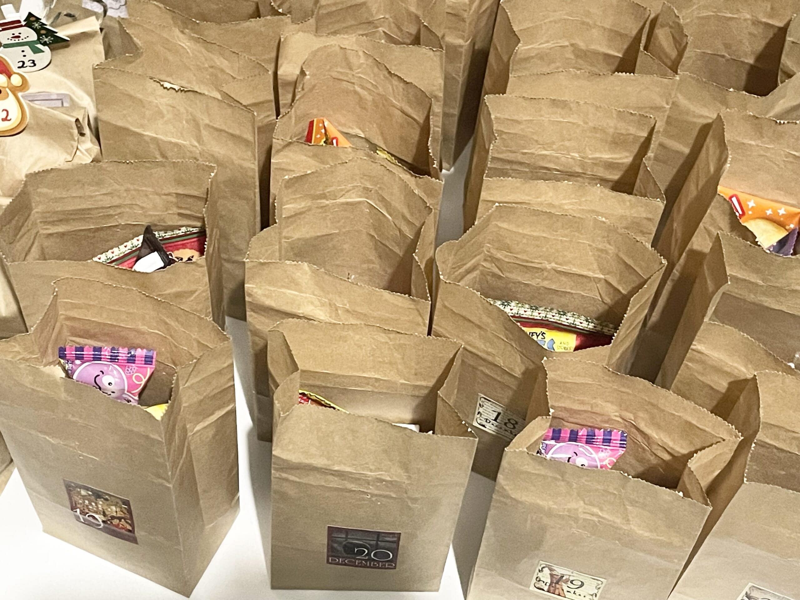 セリアのペーパークラフトバッグの中にアドベントカレンダーのお菓子を詰めている様子