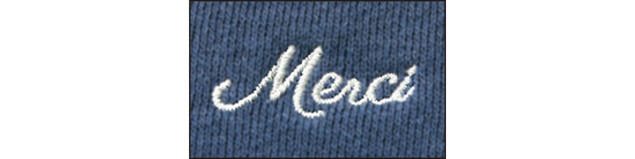 後ろの衿ぐり部分に入った「Merci」のロゴ刺しゅうが、さりげないワンポイントに。