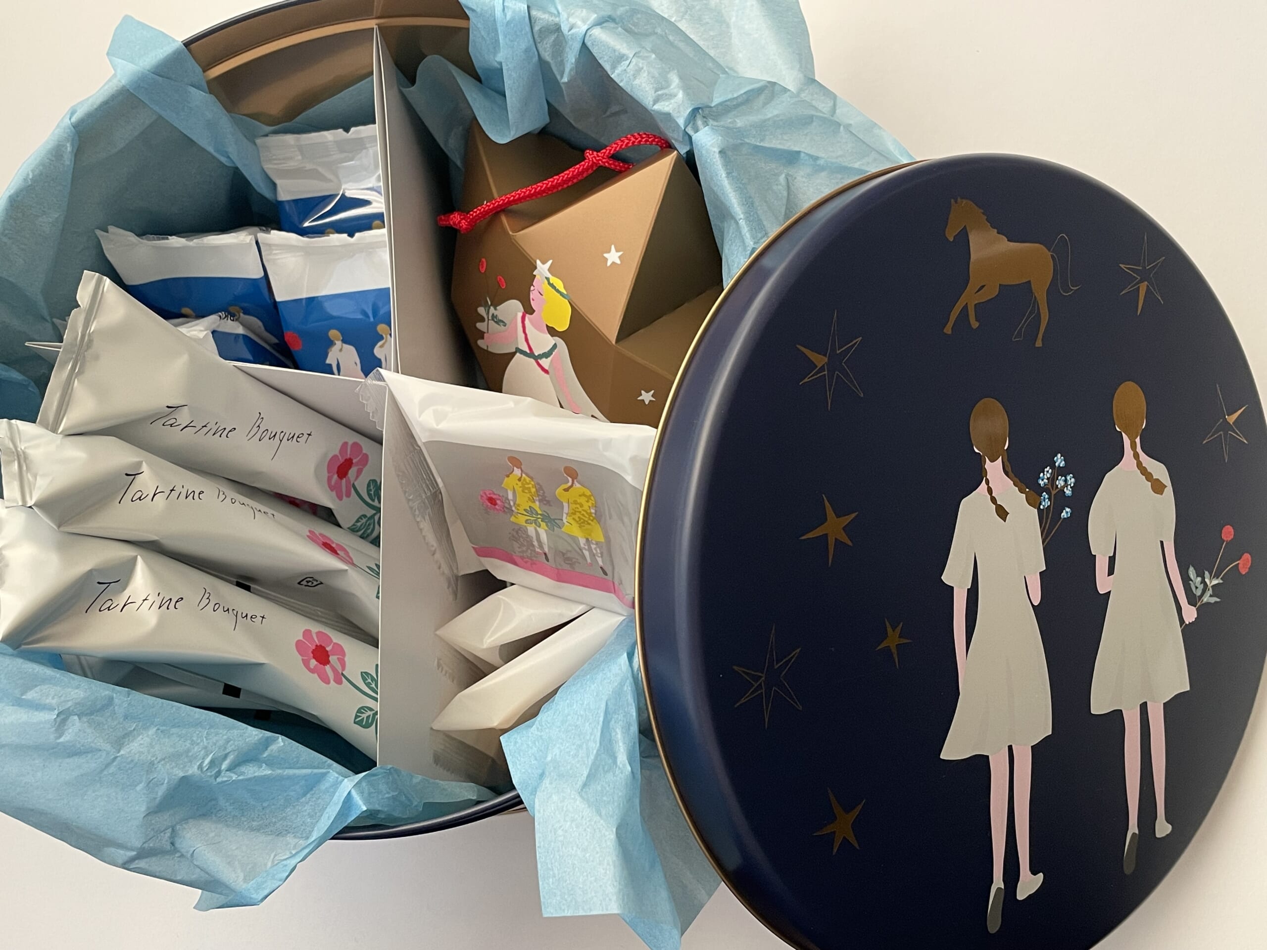 タルティンのウィンター缶2025の中身。星のオーナメントや「タルト」、「ダリア」、「タルティンブーケ」が入っている。