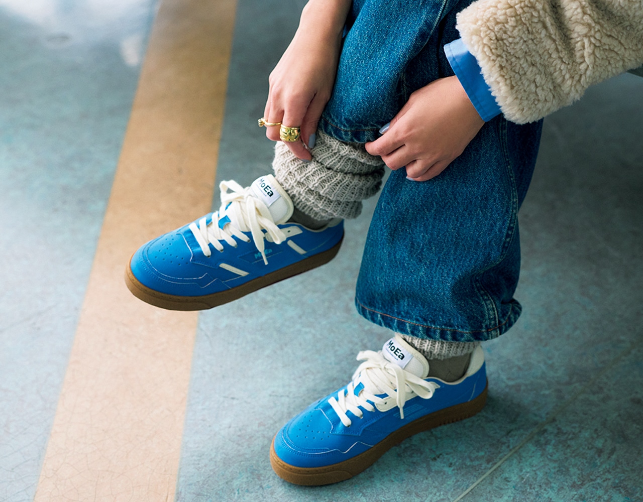 スニーカーとレッグウォーマーを着用