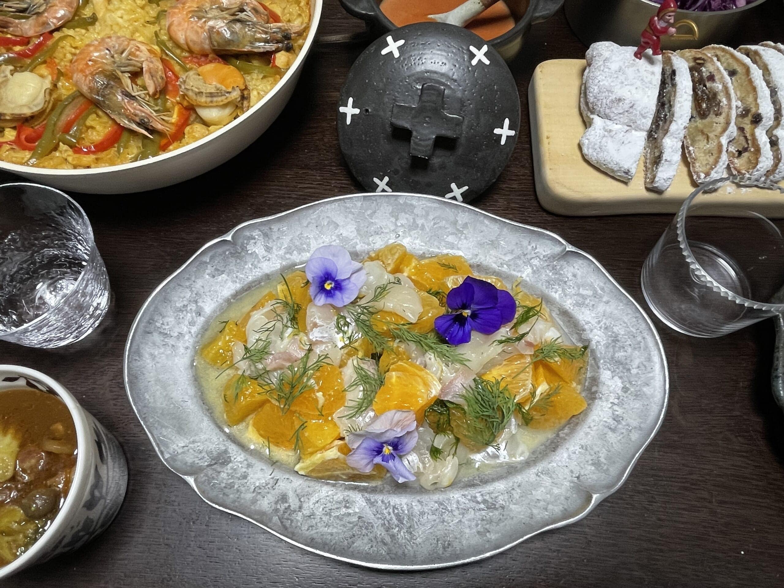 ホタテとフルーツのマリネにエディブルフラワーを添えた写真