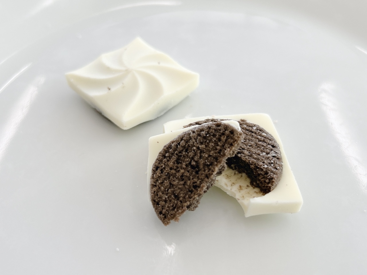 しろいし洋菓子店のショコラクッキー缶~雪降る街のちいさなおはなし 1段目「雪空にくるりと舞うシマエナガのホワイトショコラクッキー」皿カット