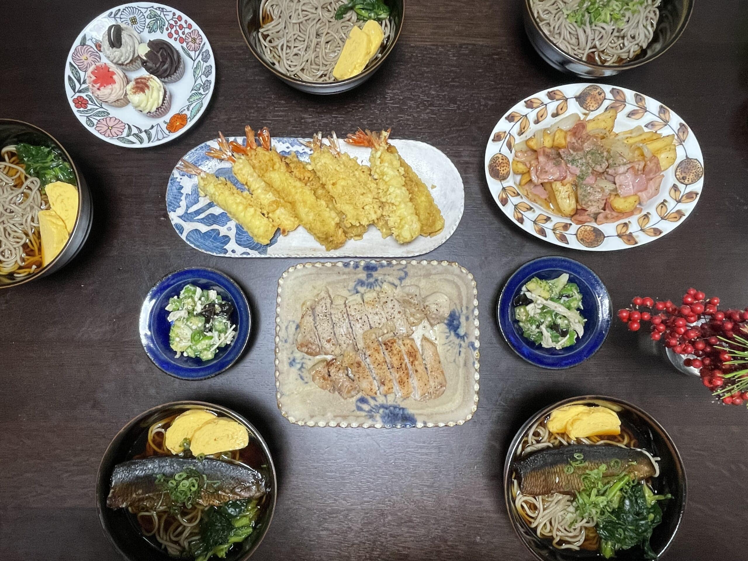 年越し蕎麦2025の食卓。ジャーマンポテトや豚肉ソテー、海老の天麩羅などがのっている。