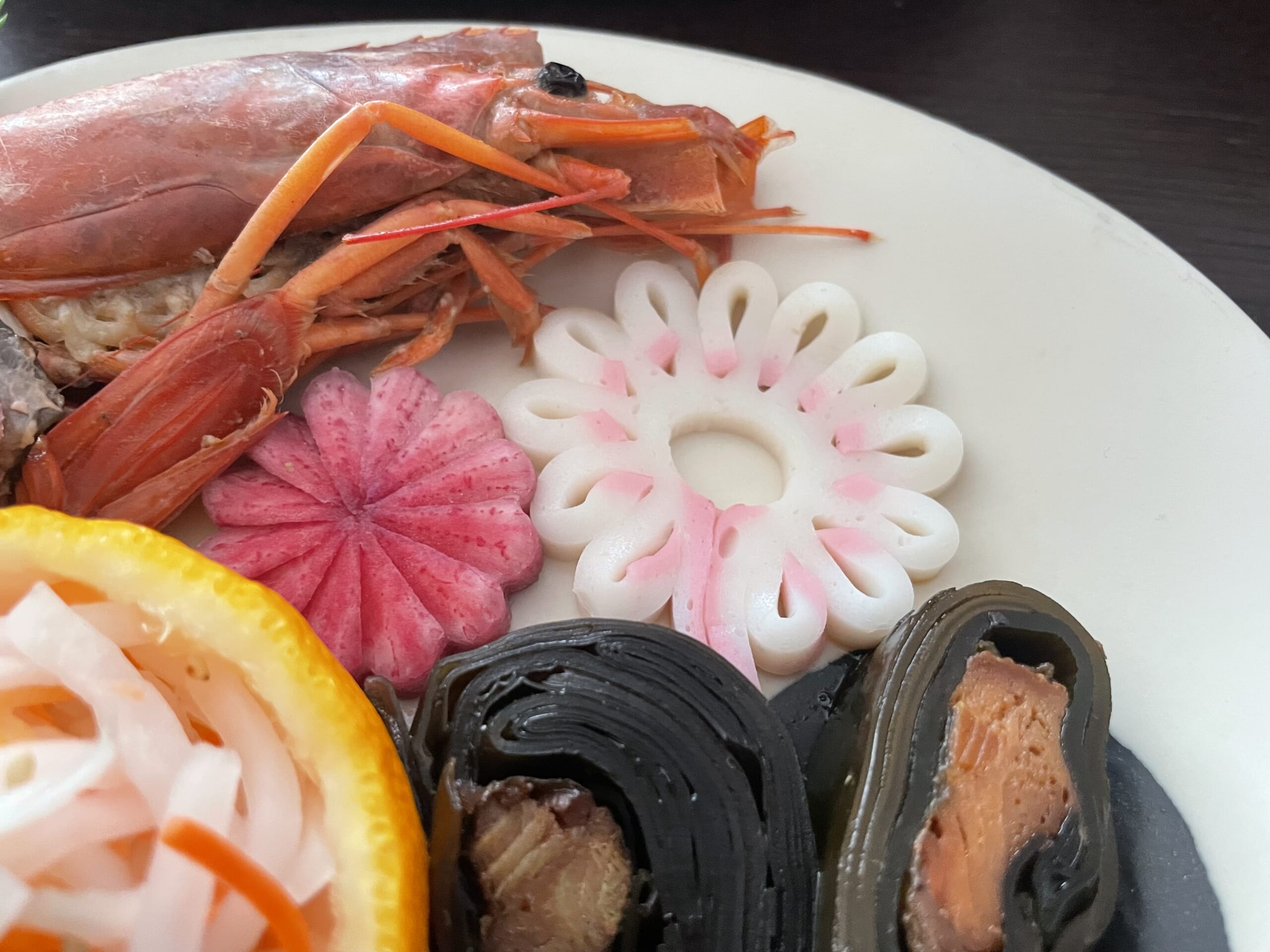 赤大根の菊型飾り切りと、紅白かまぼこのクジャク型飾り切り