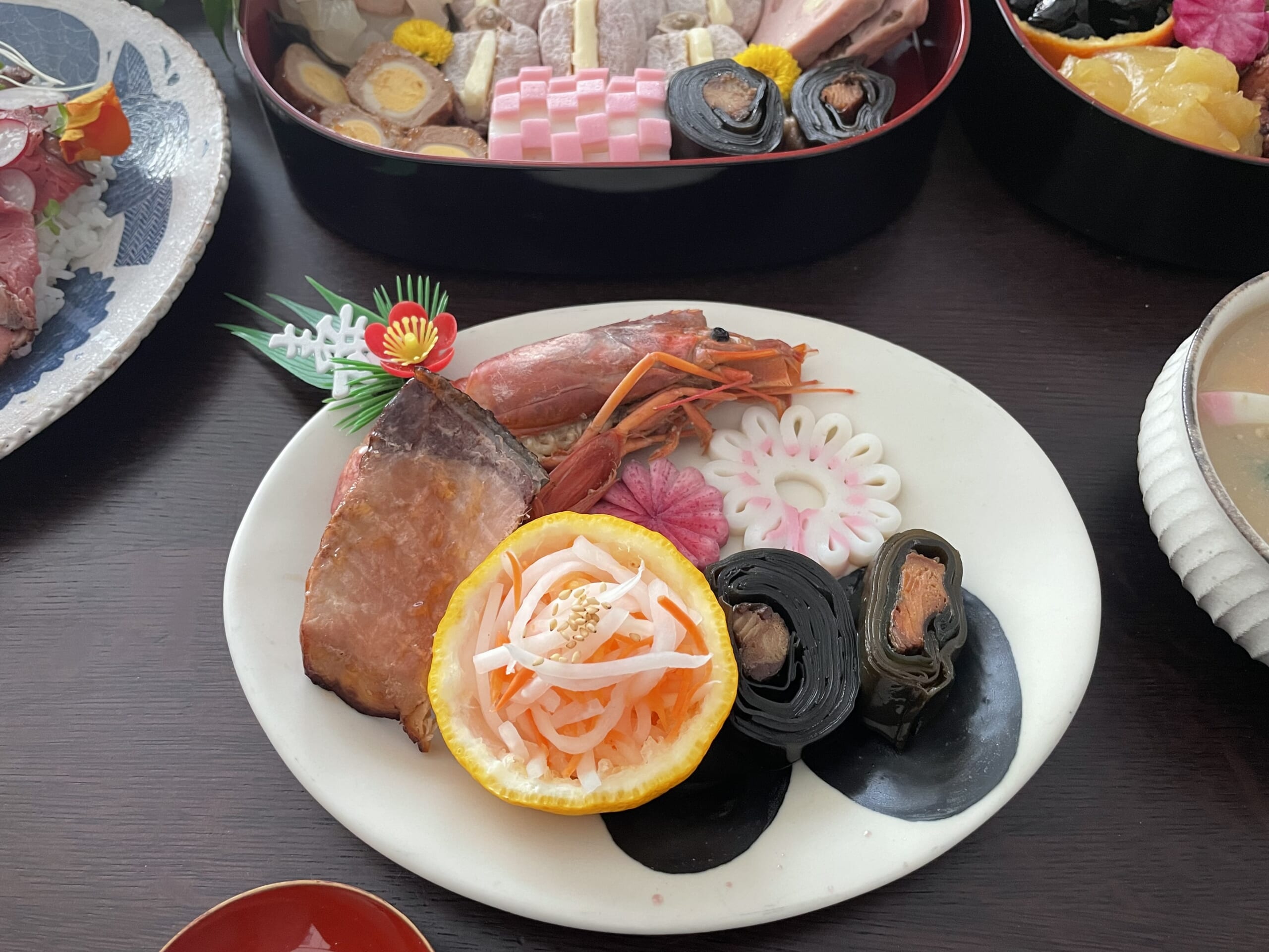 石木文さん作陶のcontes皿BLACKにおせちを盛り付けた様子