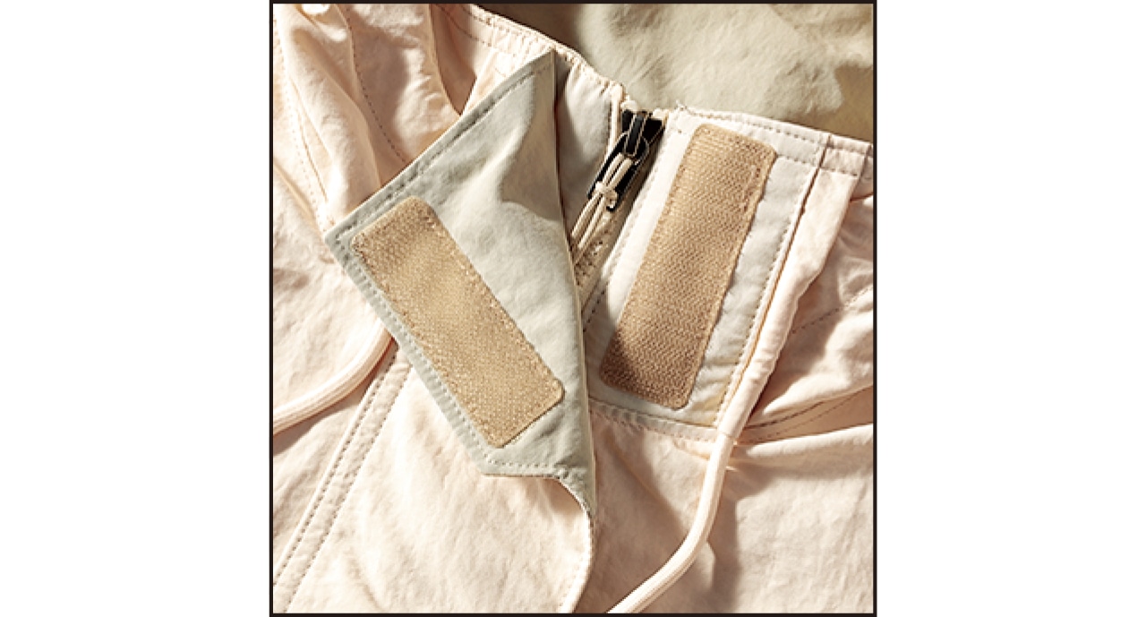 ファスナーとスナップボタンを配したフロントは、首元に面ファスナー採用。