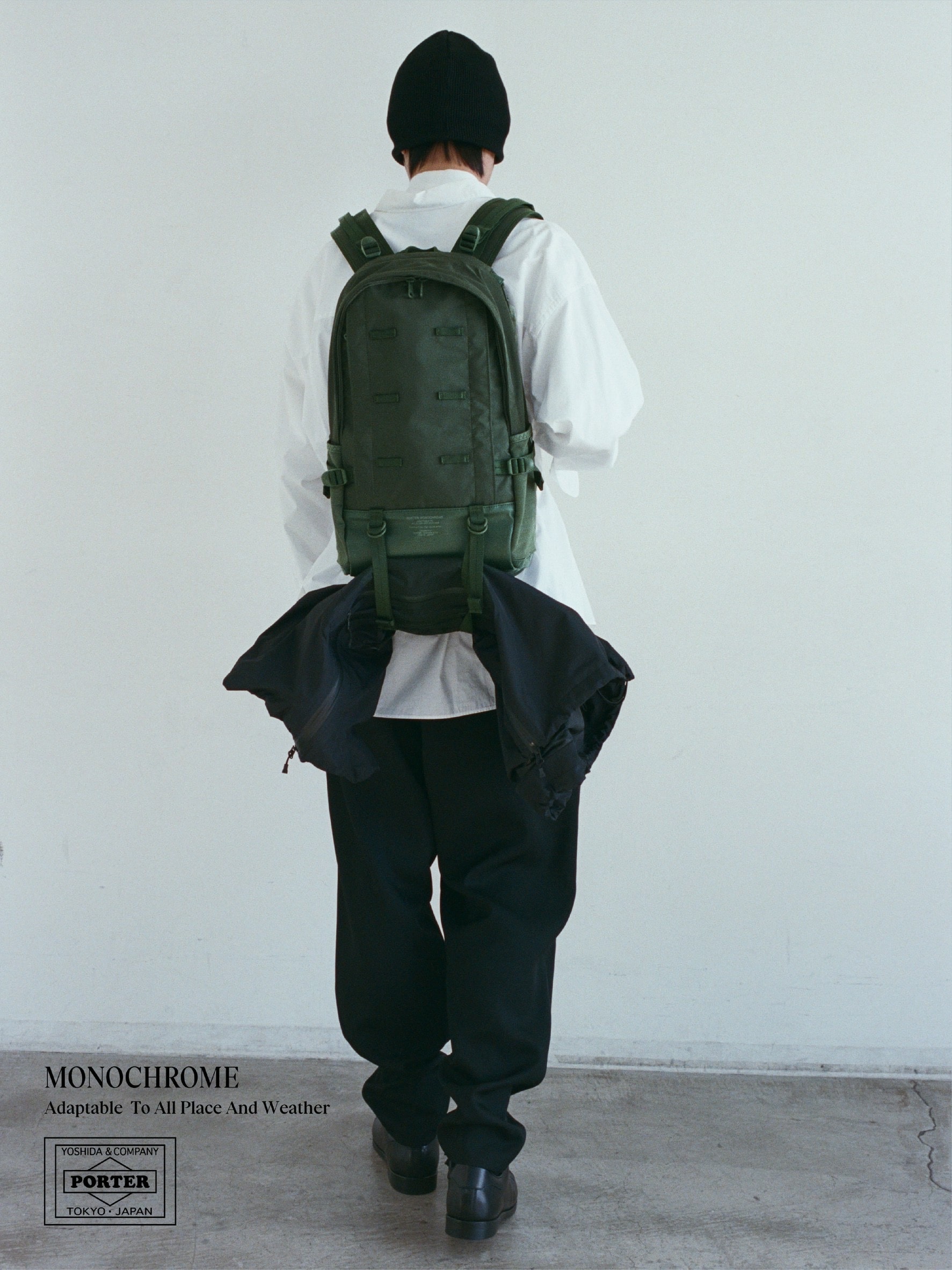 ポーターモノクロームのデイパックを背負ったモデルの後ろ姿