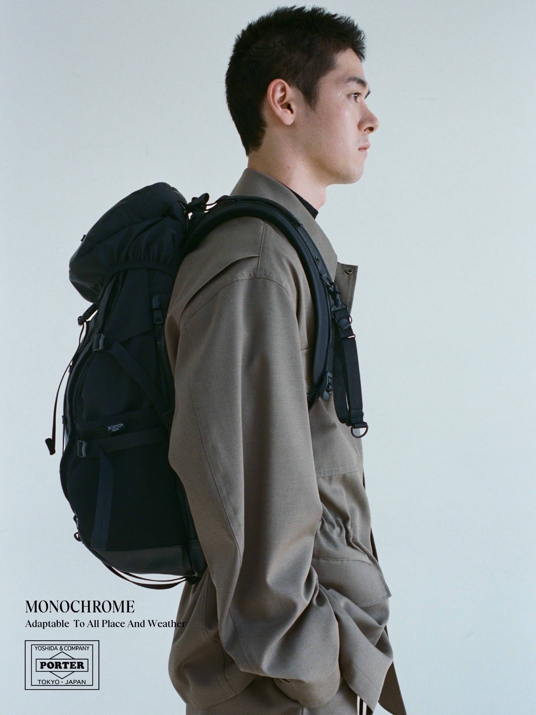 ポーターモノクロームのバックパックを背負ったモデルの横姿