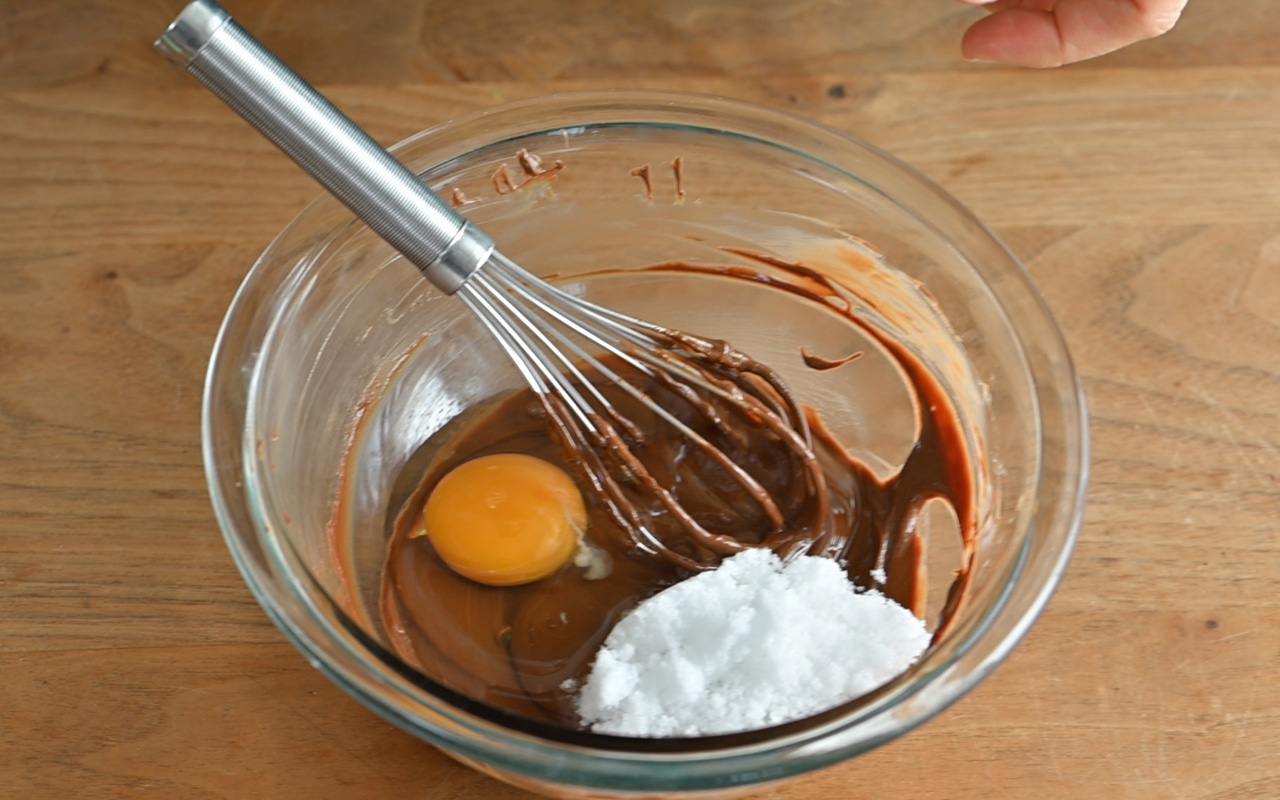 ①がすべて滑らかに溶けたら、卵と砂糖を入れて泡立て器で混ぜ、ホットケーキミックスをふるって加え、泡立て器でさっくりと混ぜ合わせる。