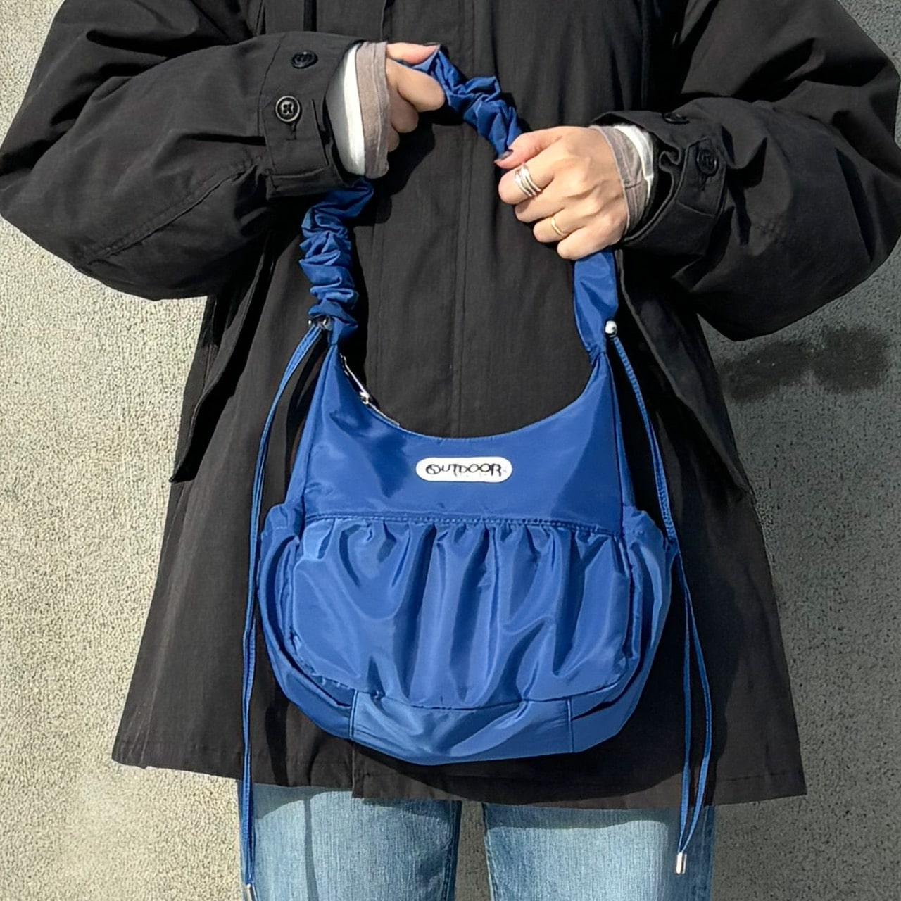 LEE別注OUTDOOR PRODUCTS×100人隊おでかけ部 可愛げ2Wayギャザーショルダーを手に持った写真