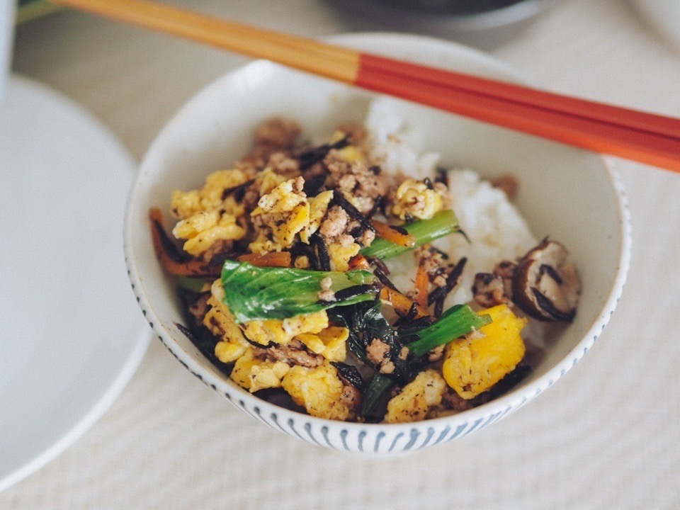 おかずをご飯の上に乗せているところ