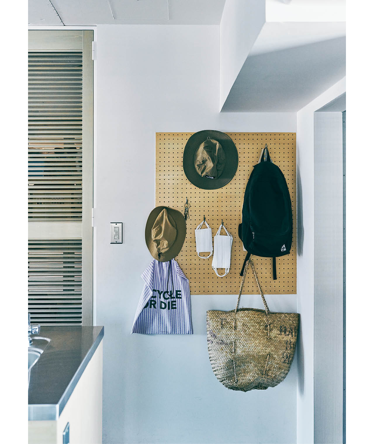 玄関横にも有孔ボードを。その隣は、長女の部屋につながる収納スペース。