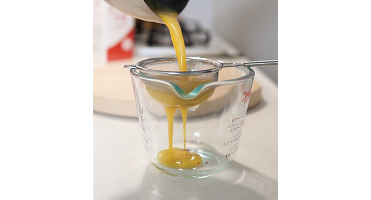 溶いた卵を茶こしでしっかりとこすことで、薄焼き卵の表面がなめらかに仕上がる。