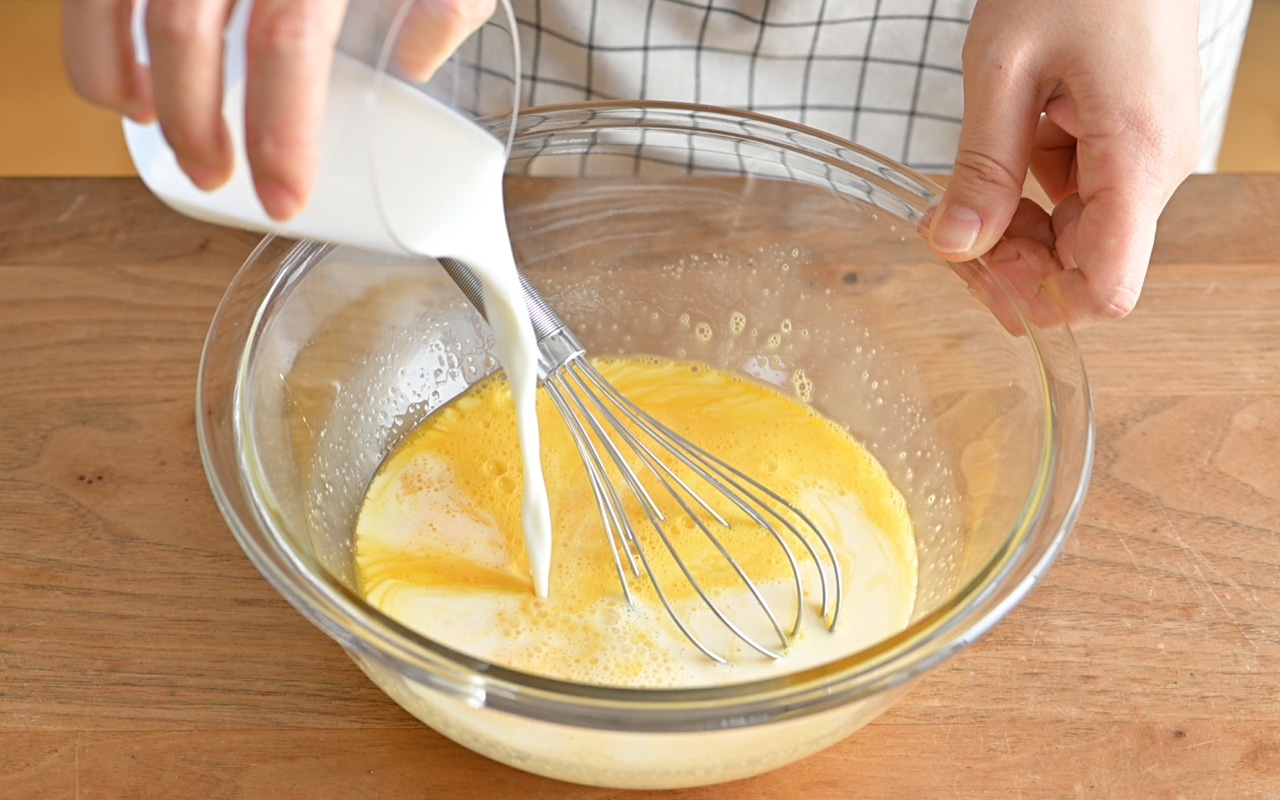 ボウルに卵をいれて泡立て器で溶きほぐし、砂糖を加えて泡立てないよう静かに混ぜる。砂糖が溶けたら牛乳を加えて混ぜ合わせプリン液を作る。