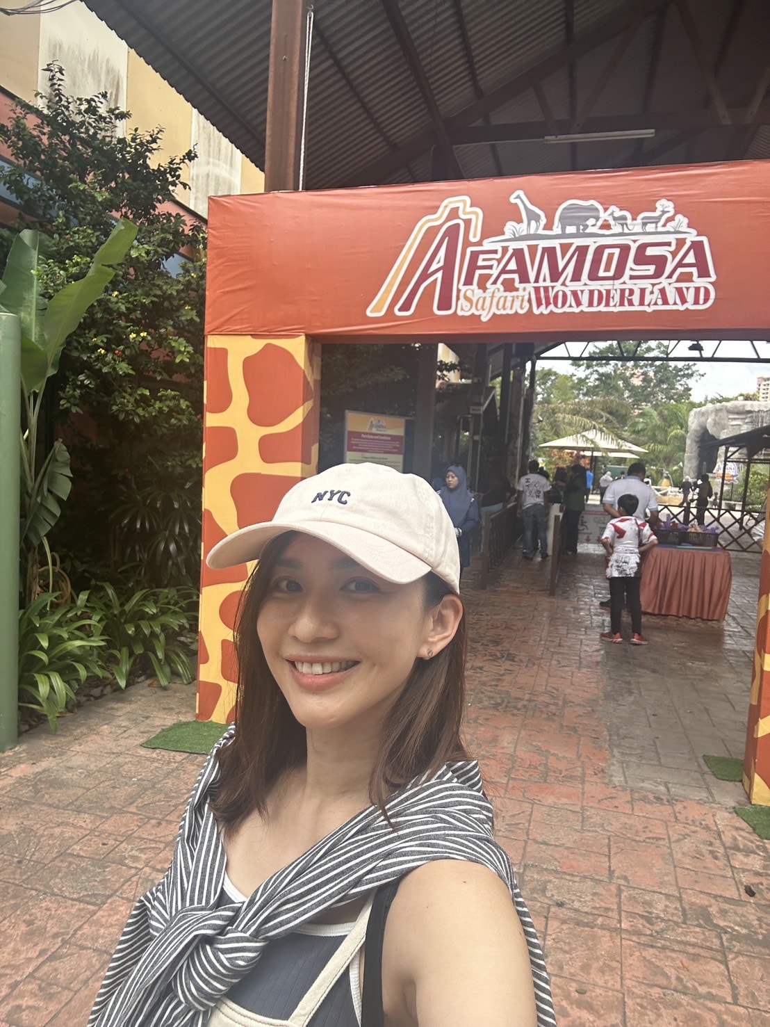 アファモサ・サファリ・ワンダーランドの看板の前に立つ優木まおみさん
