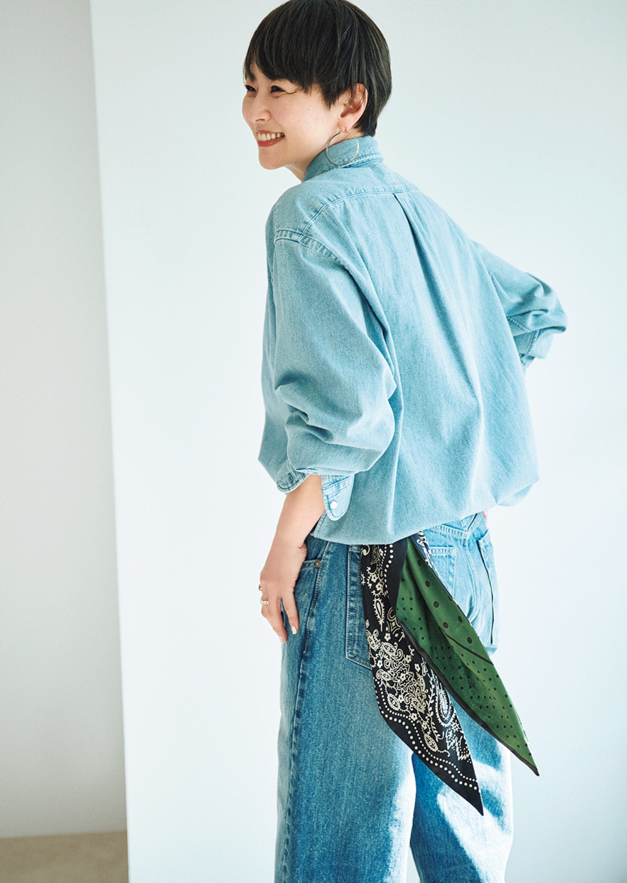 20th Anniv. LEE DAYS限定 manipuri（マニプリ）【五明祐子さんコラボ】三角スカーフ Black×Khakiをパンツのベルトループに通して腰に下げた五明祐子さん